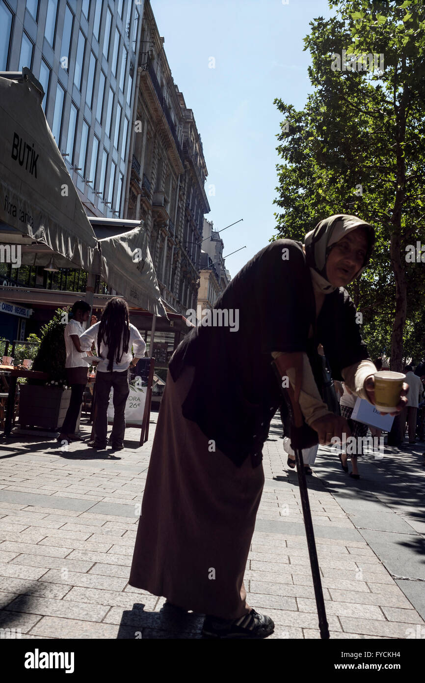 Ein Bettler bitten um Geld in einer belebten Straße in Paris. Frankreich Stockfoto