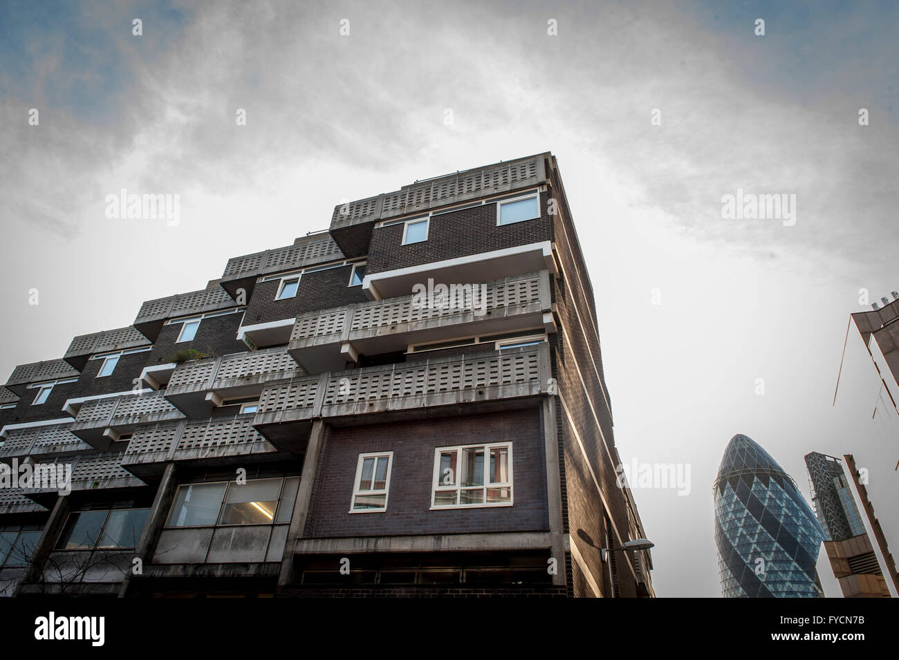 Eine Wohnsiedlung auf der Petticoat Lane in East London mit dem Gherkin im Hintergrund, der Alt und Neu kontrastiert. Stockfoto