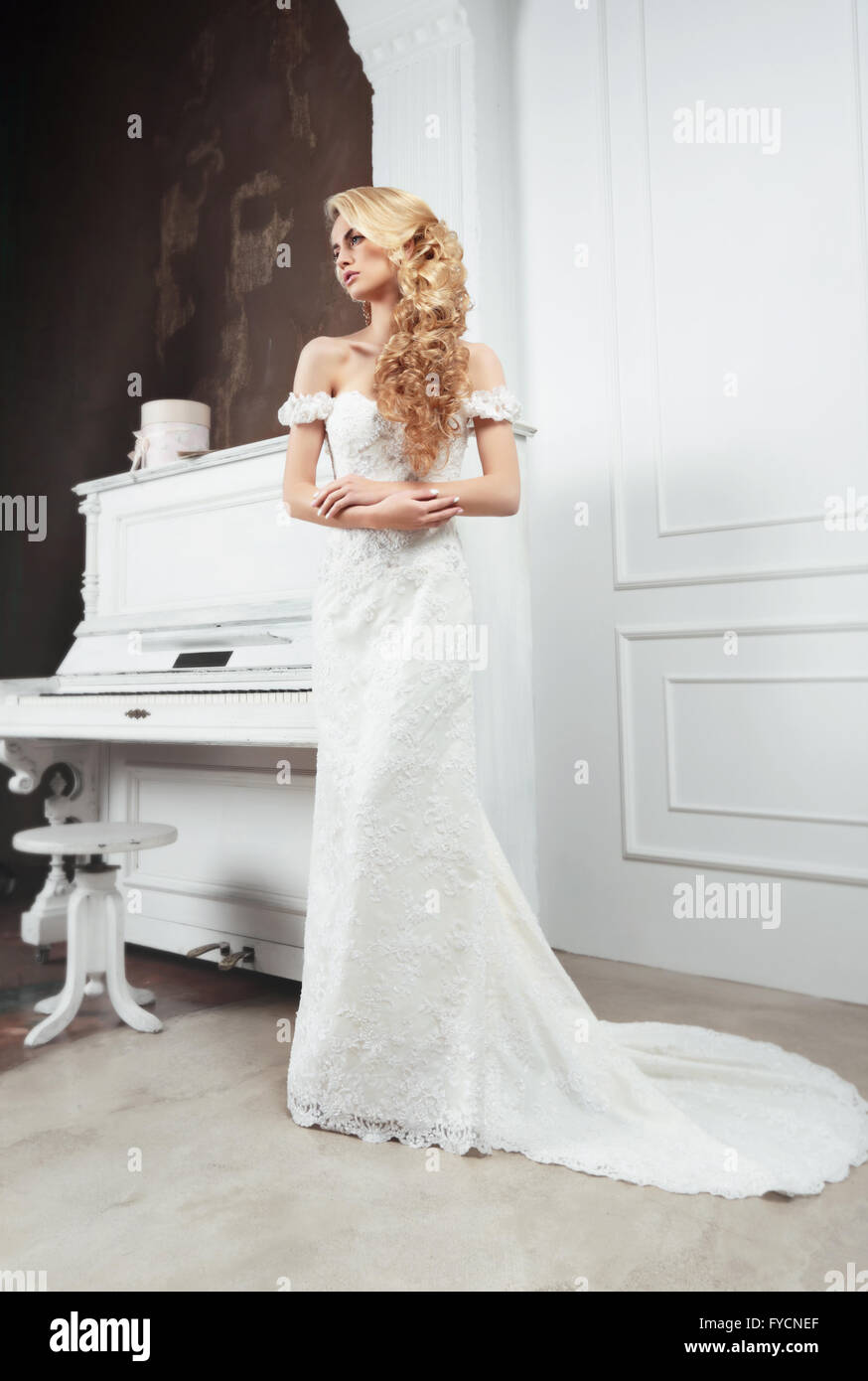 Die Braut im langen Kleid mit einem Zug. Lange helle Haare. Hochzeit Frisur. Stockfoto