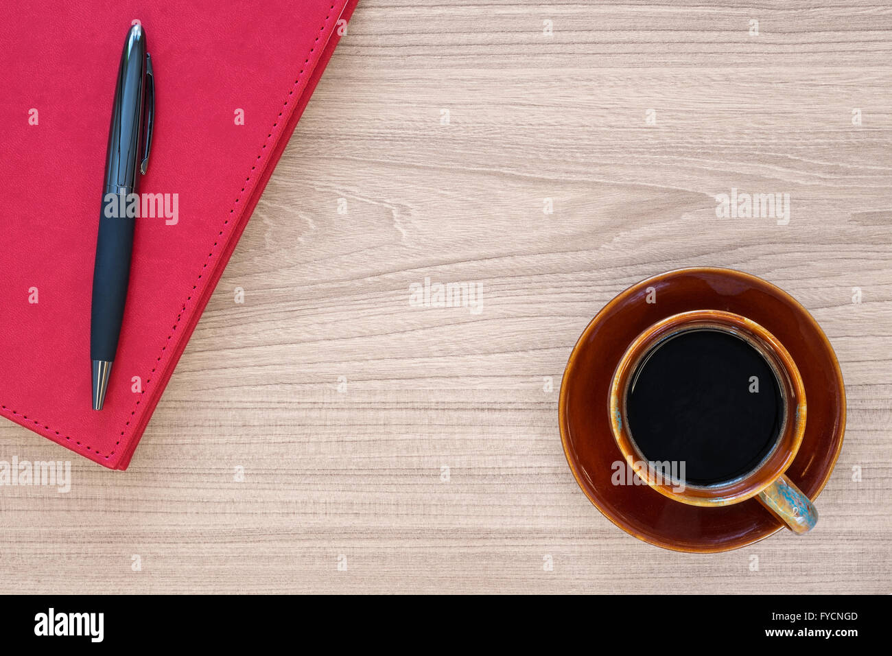 Kaffeetasse und Notizbuch mit Stift auf Holz Schreibtisch Stockfoto