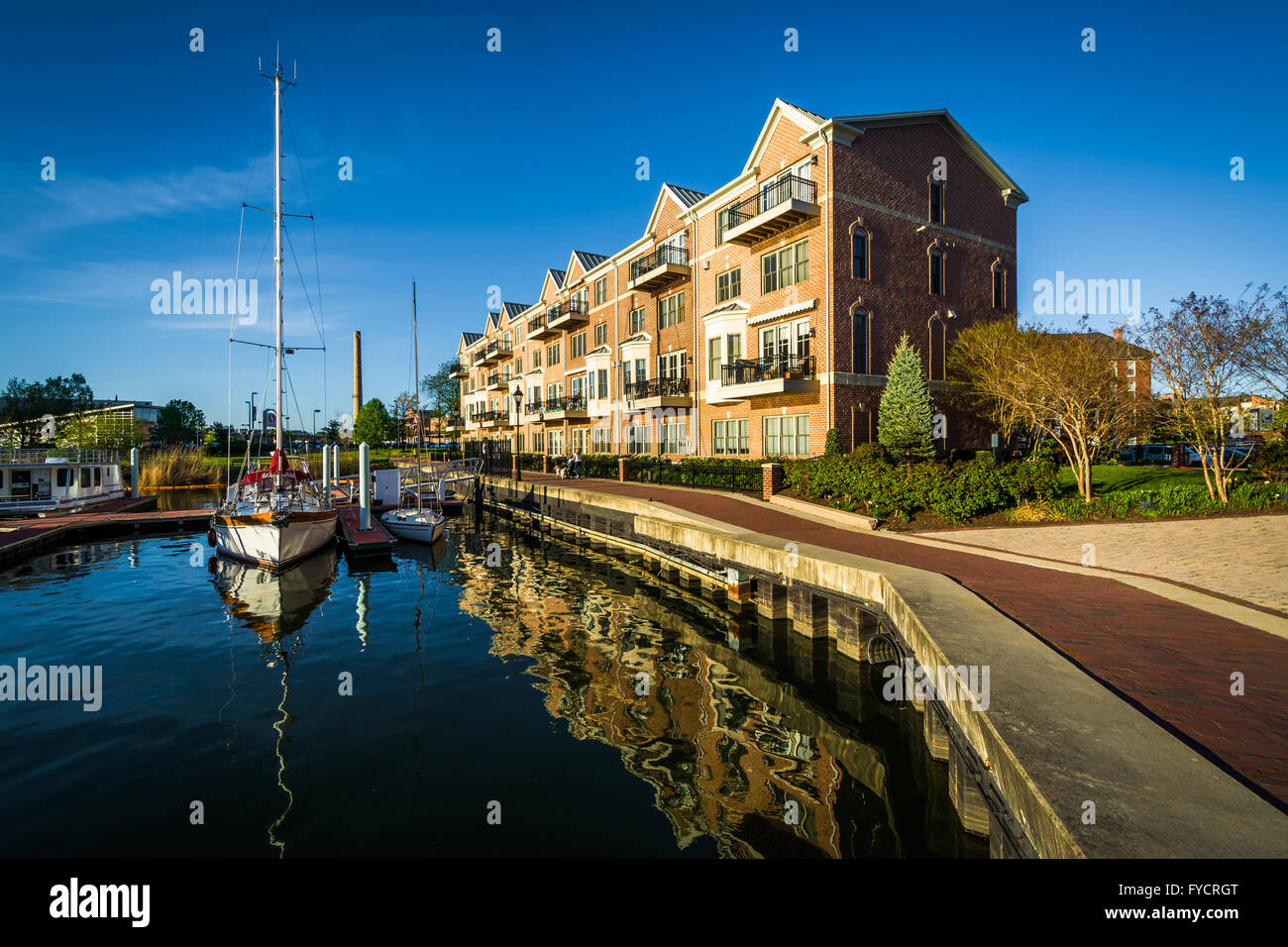 Mehrfamilienhäuser und Boote angedockt an der Uferpromenade in Kanton, Baltimore, Maryland. Stockfoto