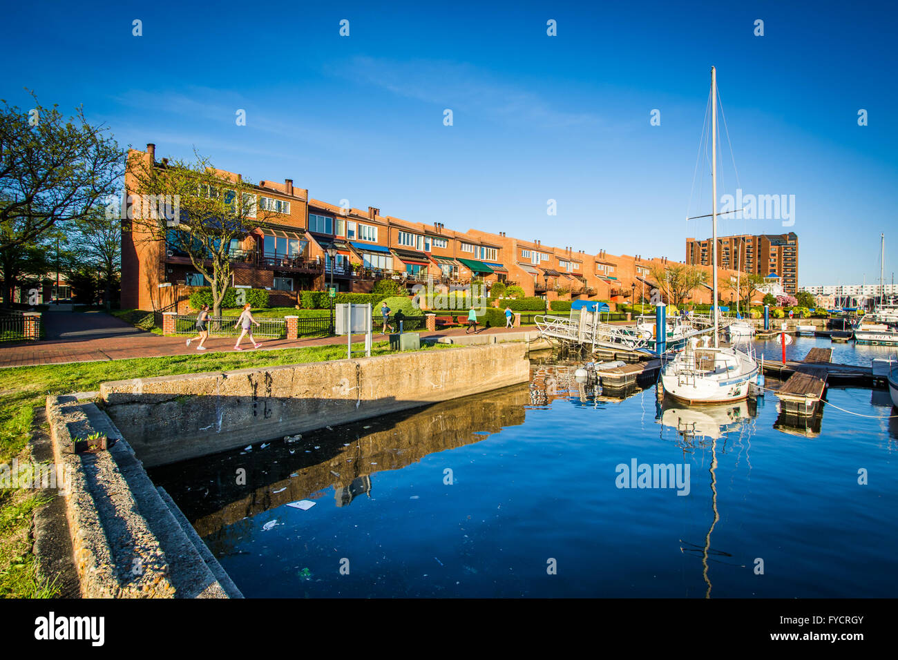 Mehrfamilienhäuser und Boote angedockt an der Uferpromenade in Kanton, Baltimore, Maryland. Stockfoto