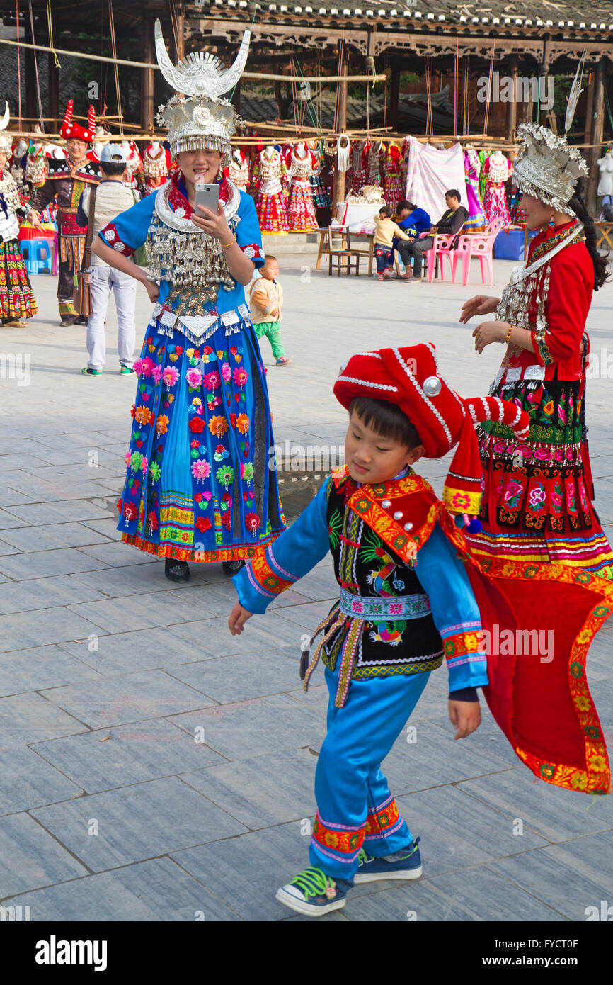 Jungen spielen in Dong Tracht in Xijiang Dorf Stockfoto