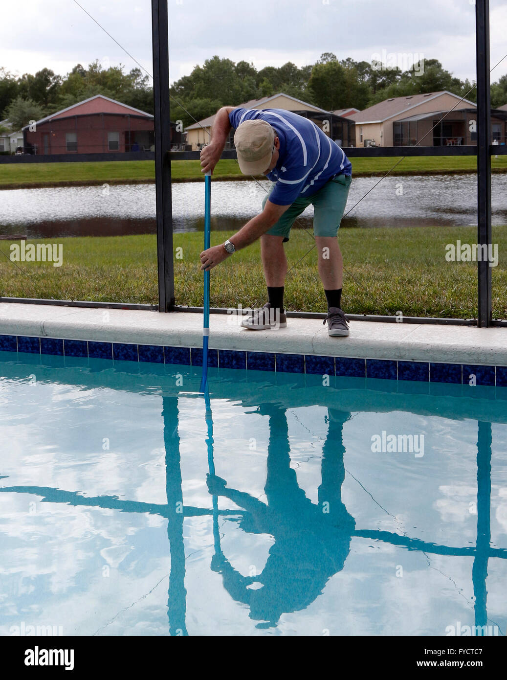 Reifer Mann tun Poolpflege zu seinem Florida Pool Zuhause, 25. April 2016 Stockfoto