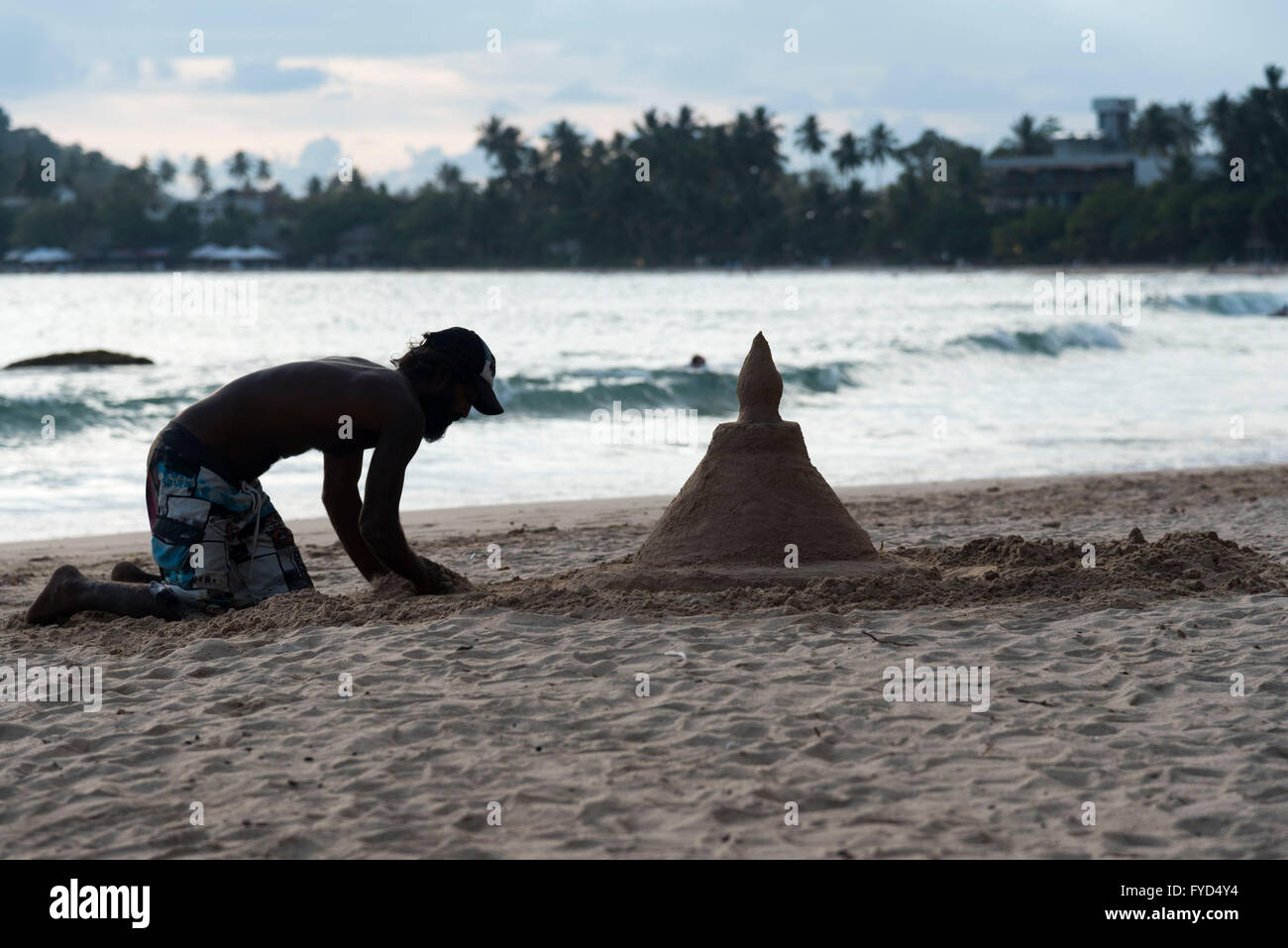 Ein Mann macht eine Sandburg am Strand im Süden Sri Lankas Stockfoto