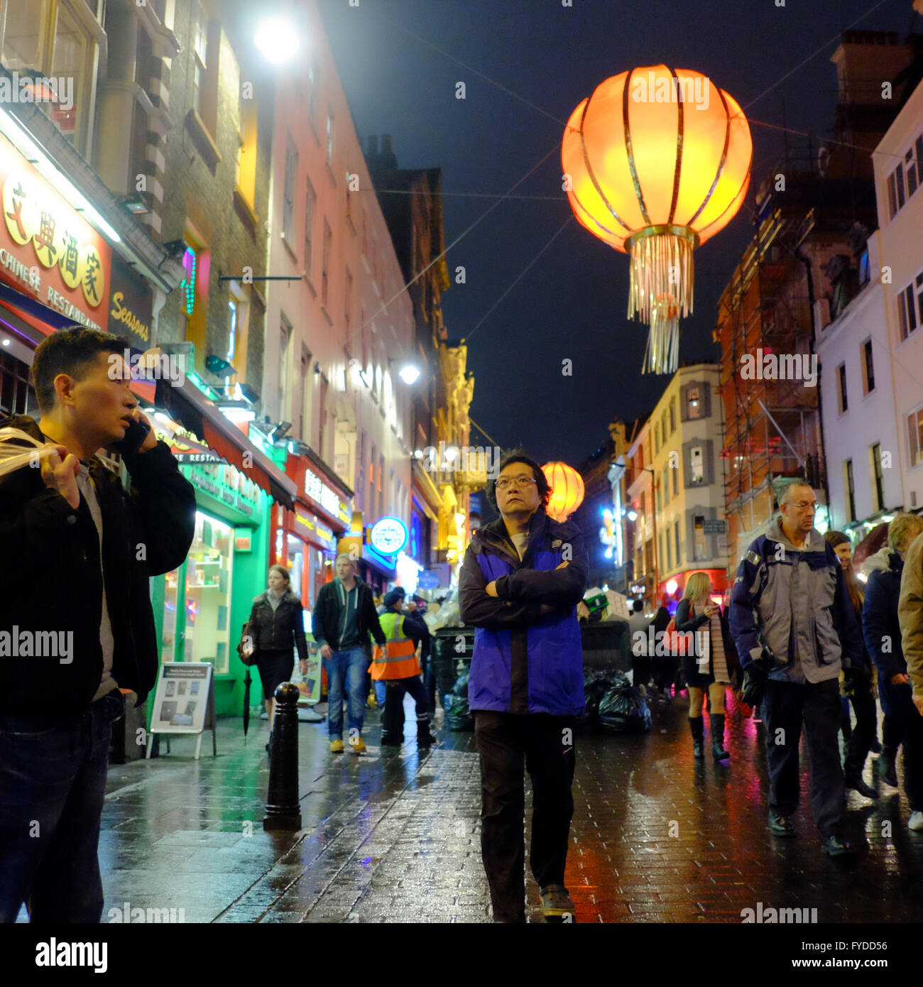 Mann mit verschränkten Armen durch Chinatown, Soho, London Stockfoto