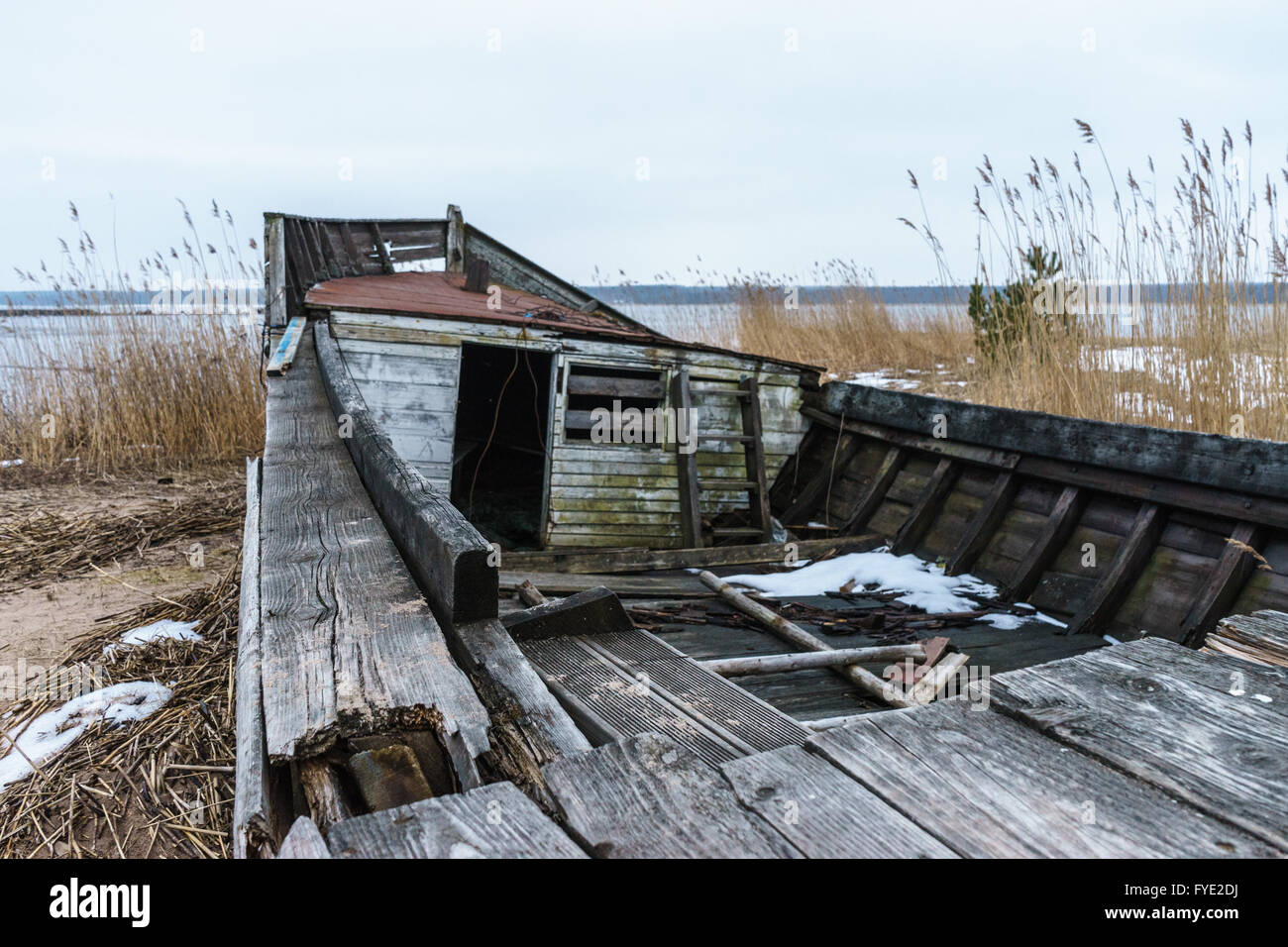 Verlassene und gebrochenen kleinen Holzschiff am Meer im Winter Stockfoto