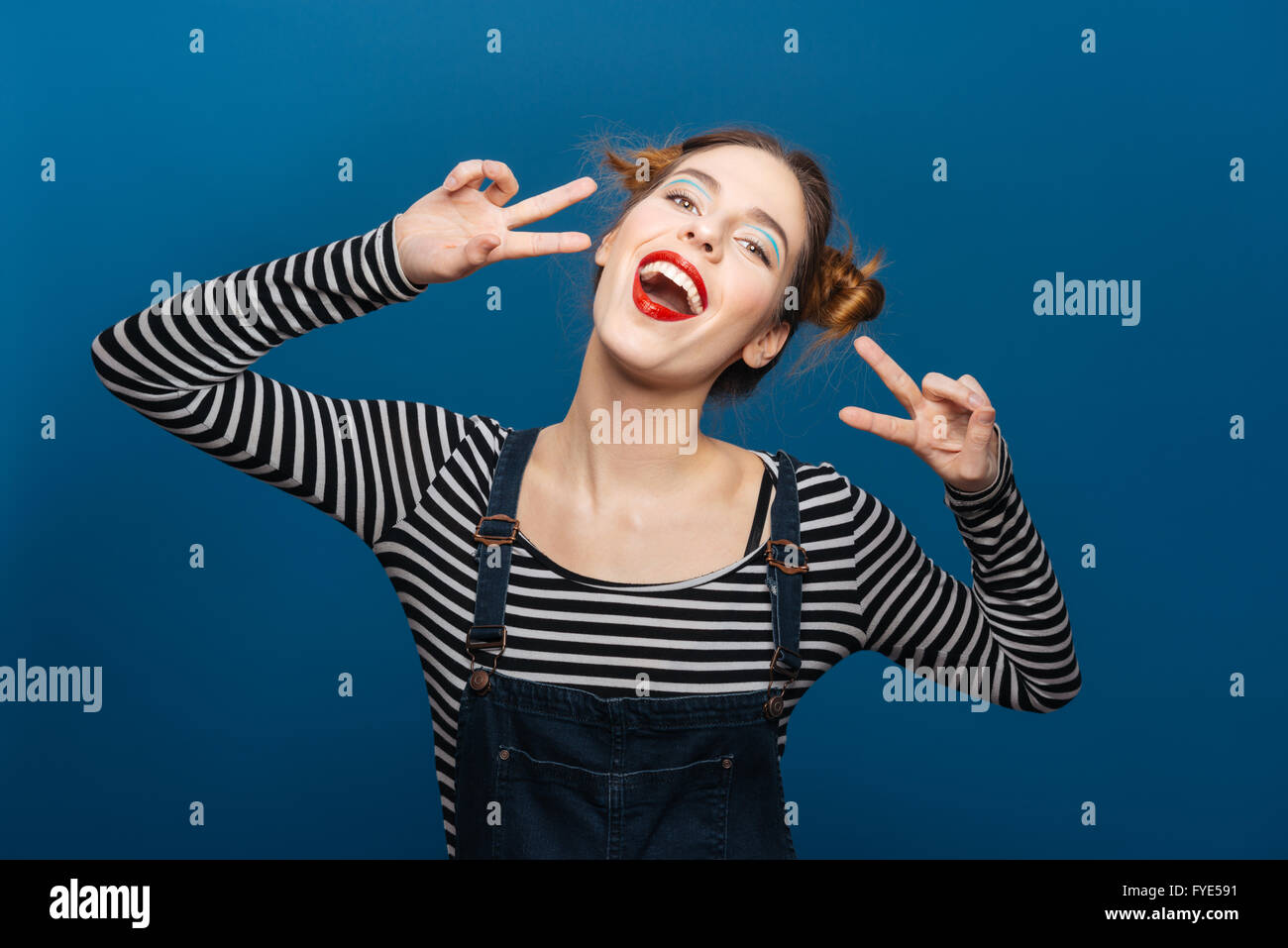 Glücklich süße junge Frau, die mit Peace-Zeichen Stockfoto