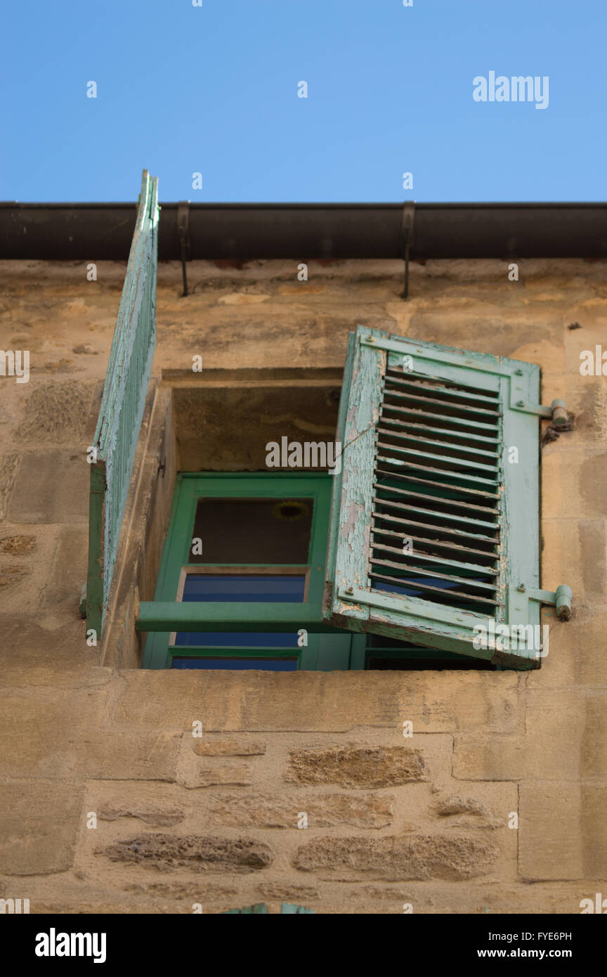 Abblätternde Farbe auf einem grünen Fensterläden auf einem Stein französischen Haus in der Dordogne-Region von Frankreich Stockfoto