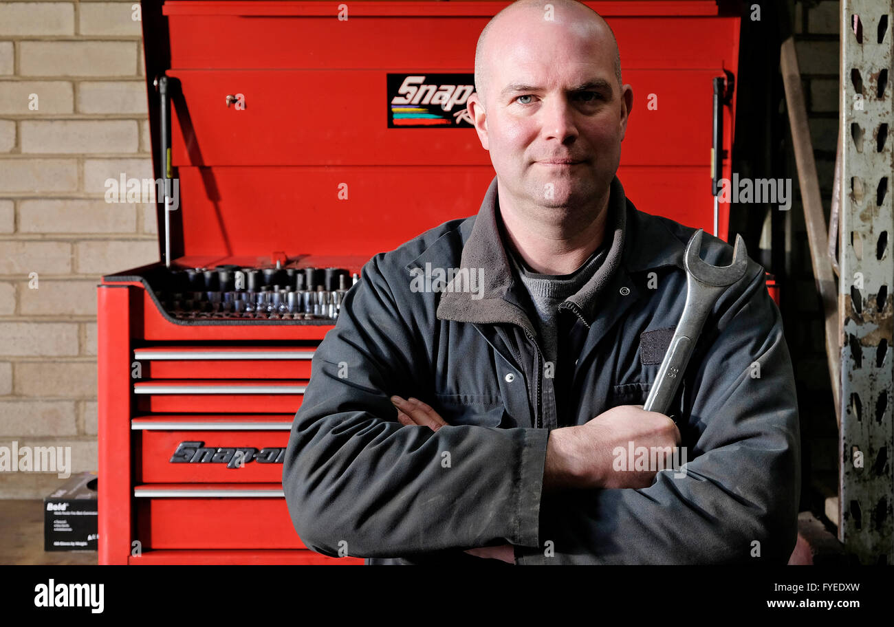 männliche motor mechanische stand vor Werkzeugkasten Stockfoto