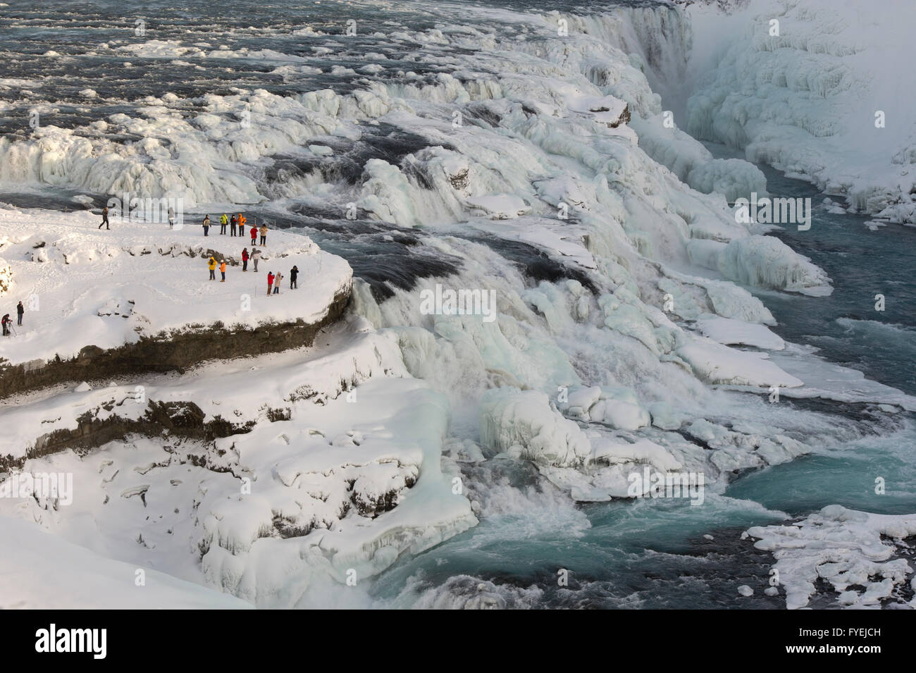 Touristen, die den Gullfoss Wasserfall im Winter in Island anzeigen Stockfoto