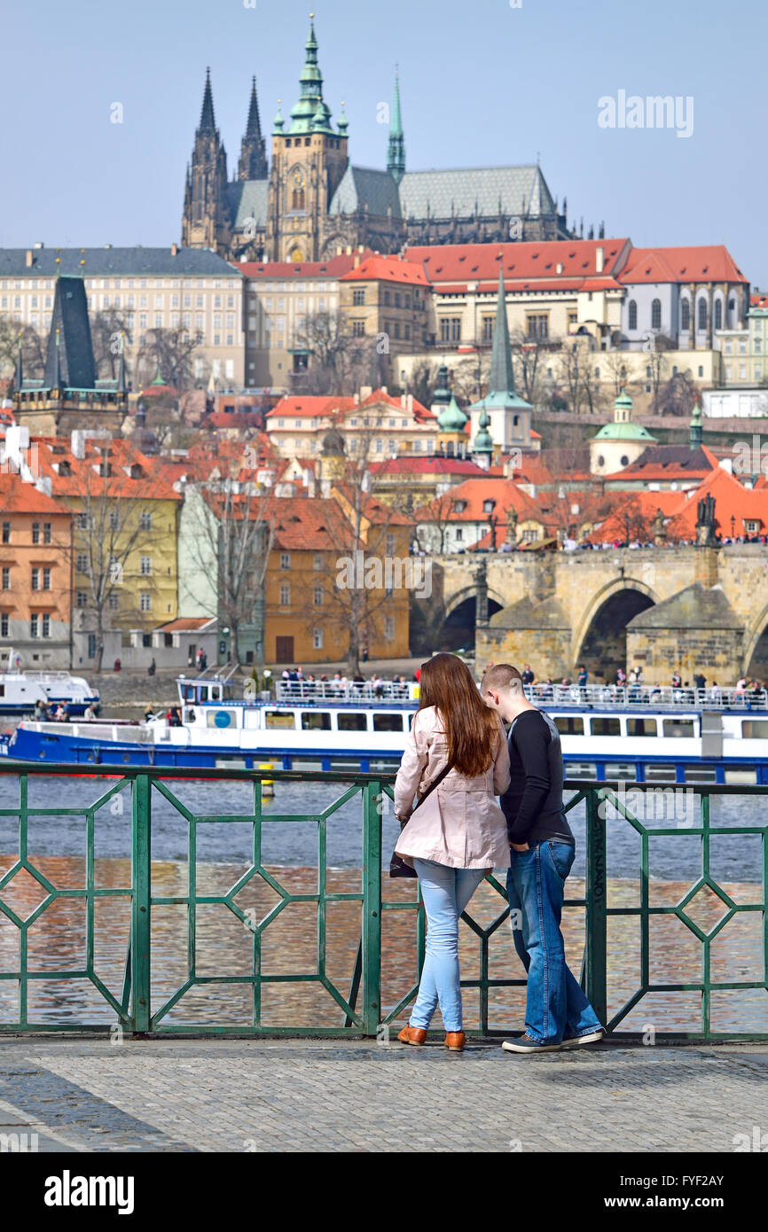 Prag, Tschechische Republik. Junges Paar auf Smetana Nabrezi (Smetana Damm) mit Blick auf den Fluss Vltava zum Schloss... Stockfoto