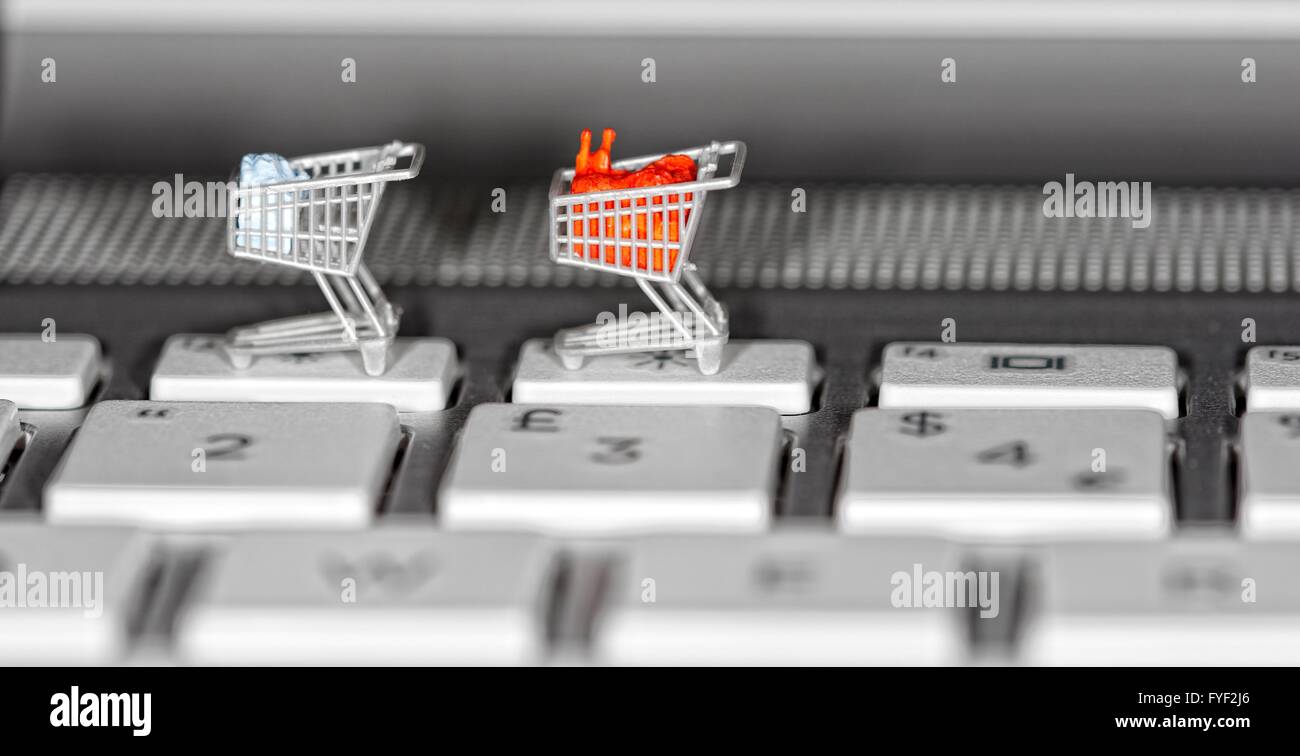 Supermarkt-Einkaufswagen auf einer Laptoptastatur hautnah. Stockfoto