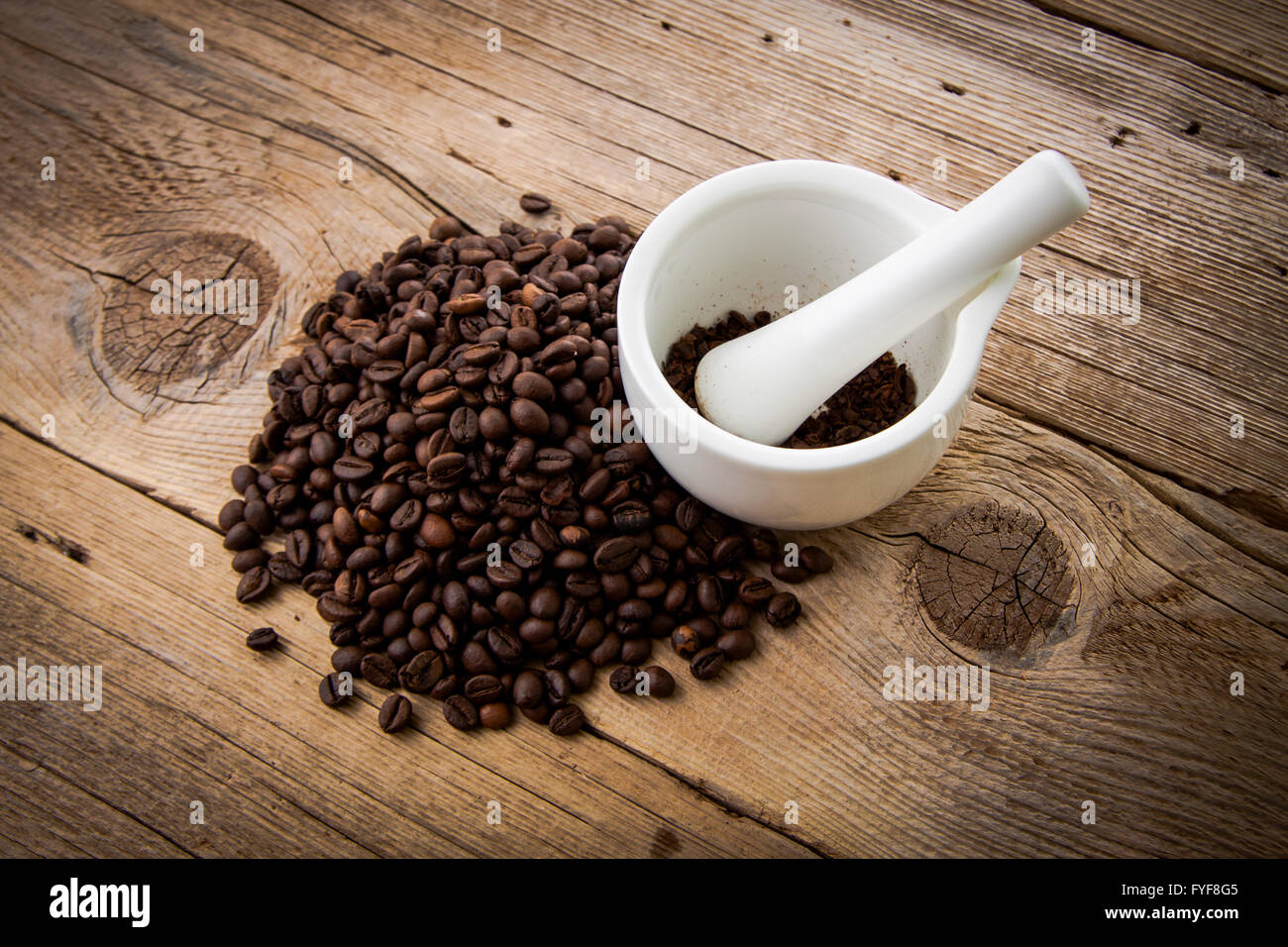 Kaffee Bohnen auf rustikalen hölzernen Hintergrund und weißem Mörtel Stockfoto