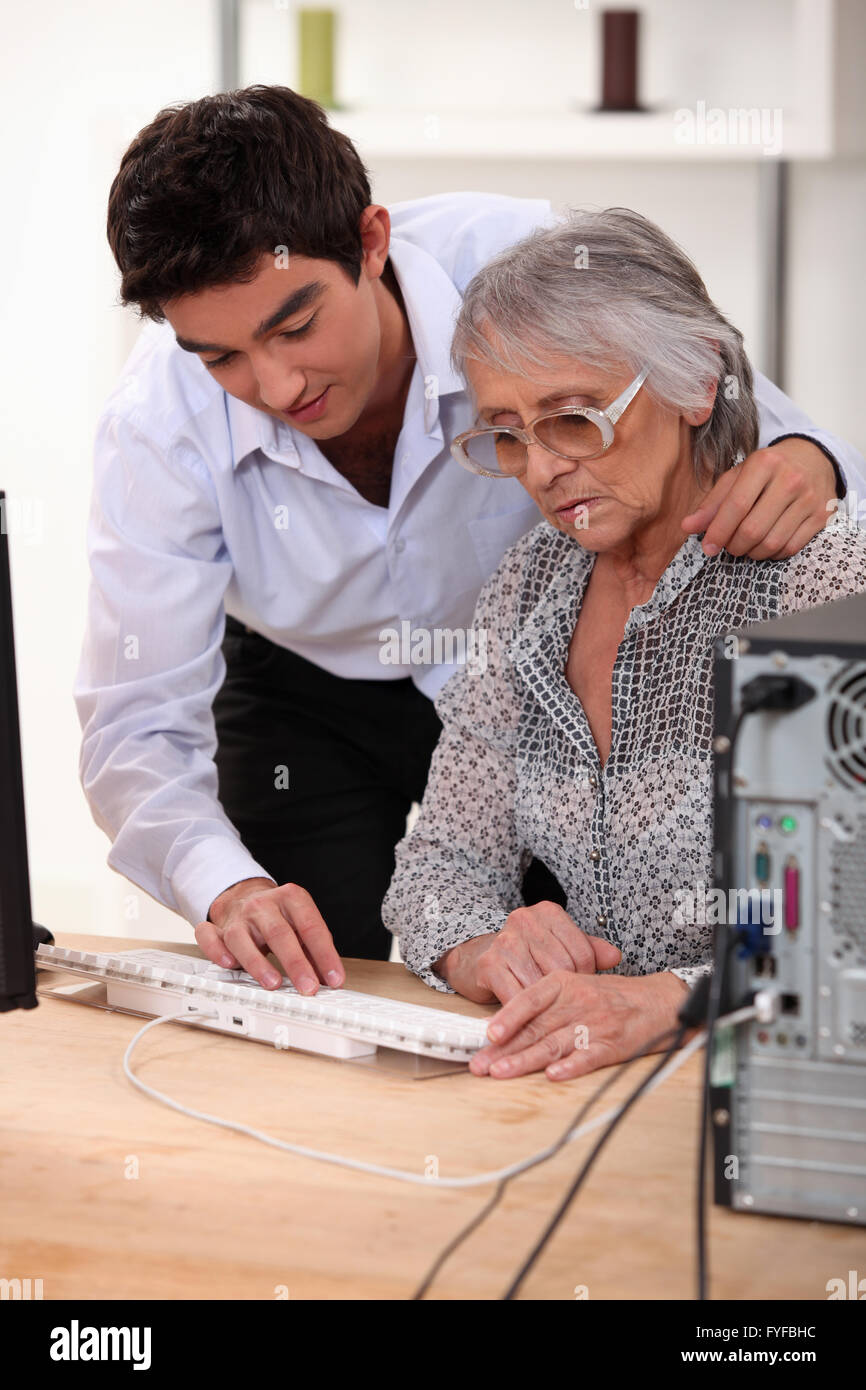Enkel, Großmutter zeigt, wie man Computer verwenden Stockfoto