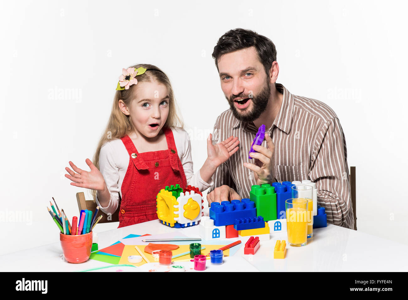 Vater und Tochter zusammen spielen Lernspiele beide glücklich lächelnd auf dem weißen Hintergrund Stockfoto