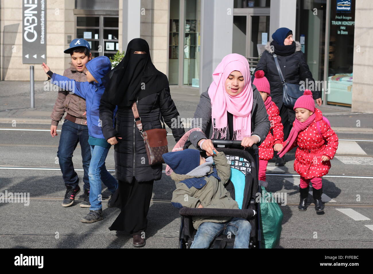 Familie von Flüchtlingen mit Burka und Kopftuch auf einer Straße in Bonn, Deutschland Stockfoto