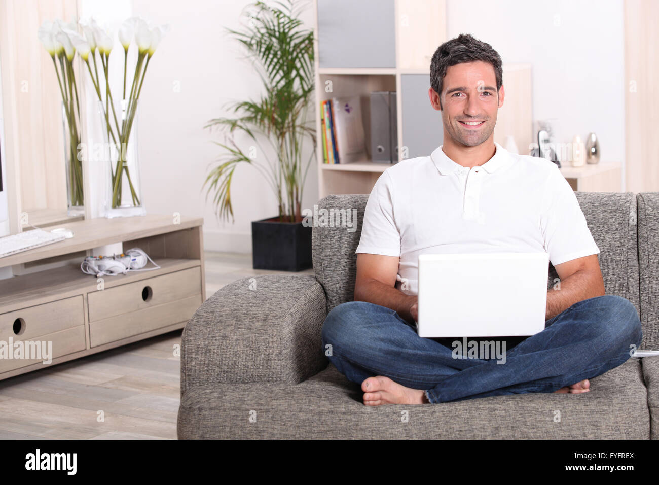 Mann mit einem Laptopcomputer in seine Stube Stockfoto