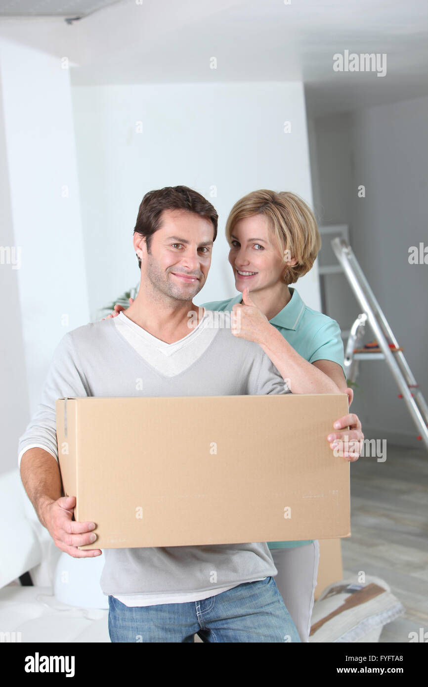 Frau die Daumen hoch für ihre Partner zu geben, wie sie in ein neues Zuhause einziehen Stockfoto