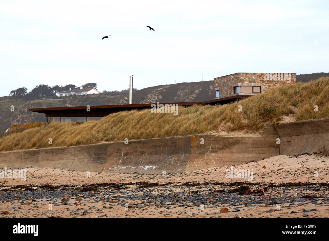 Blick vom Strand unten zeigt Haus "versteckt" in den Dünen. Le Petit Fort, St. Helier, Großbritannien. Architekt: Hudson Architekten, 2016. Stockfoto