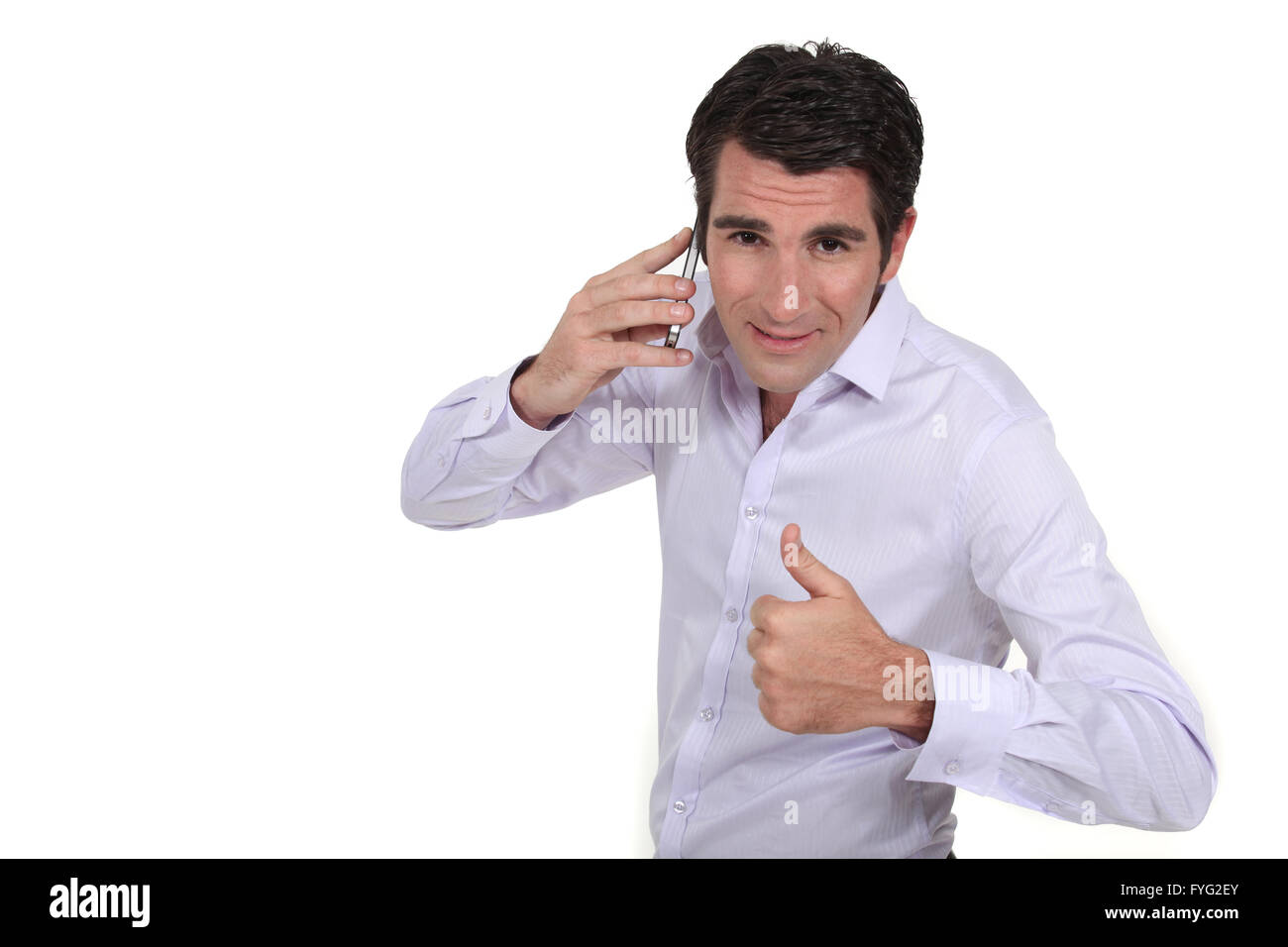 Ein Geschäftsmann am Telefon den Daumen aufgeben. Stockfoto