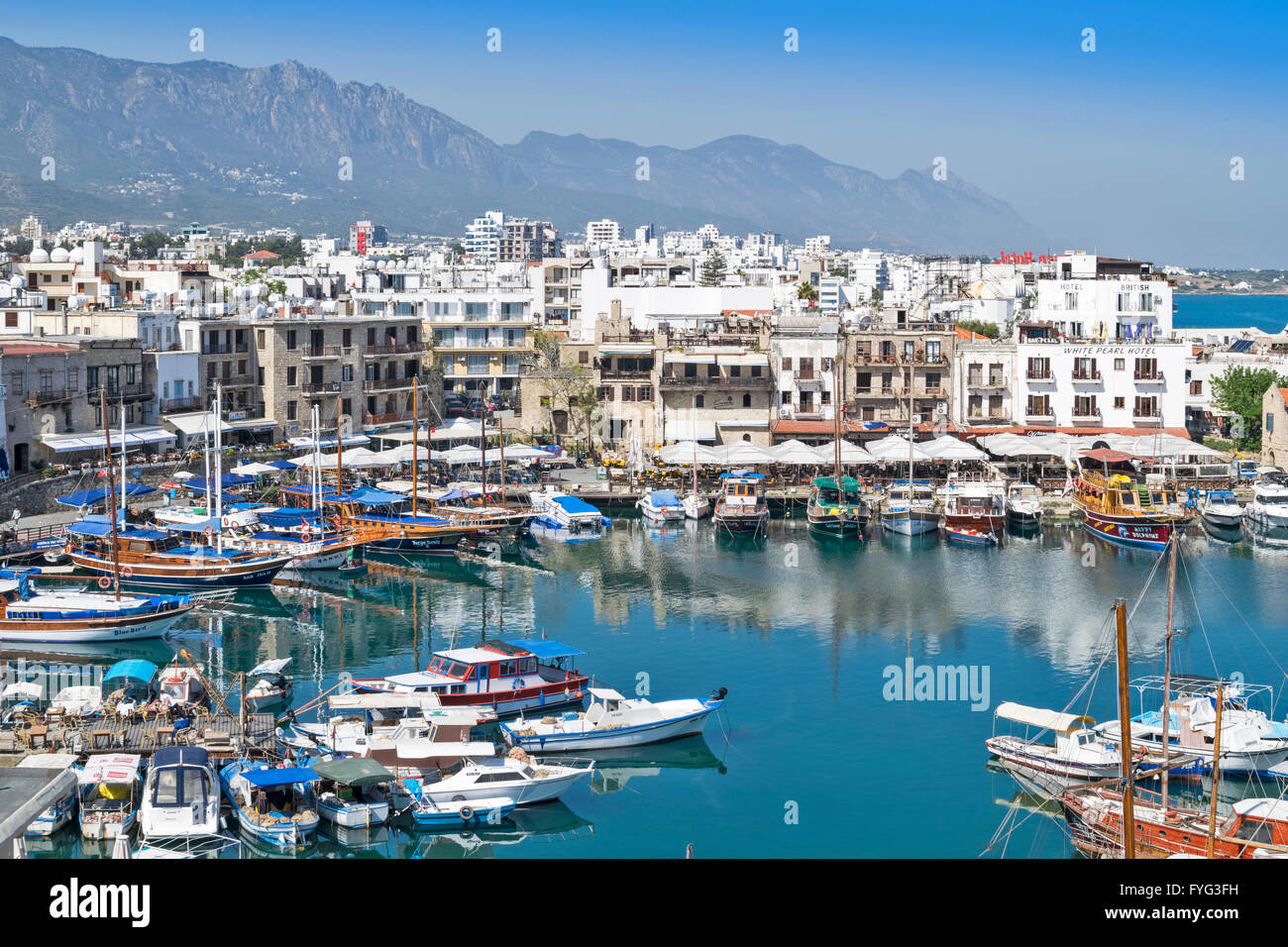 NORD-ZYPERN KYRENIA KREISFÖRMIGE HAFEN MIT BOOTEN HÄUSER UND HÜGEL Stockfoto