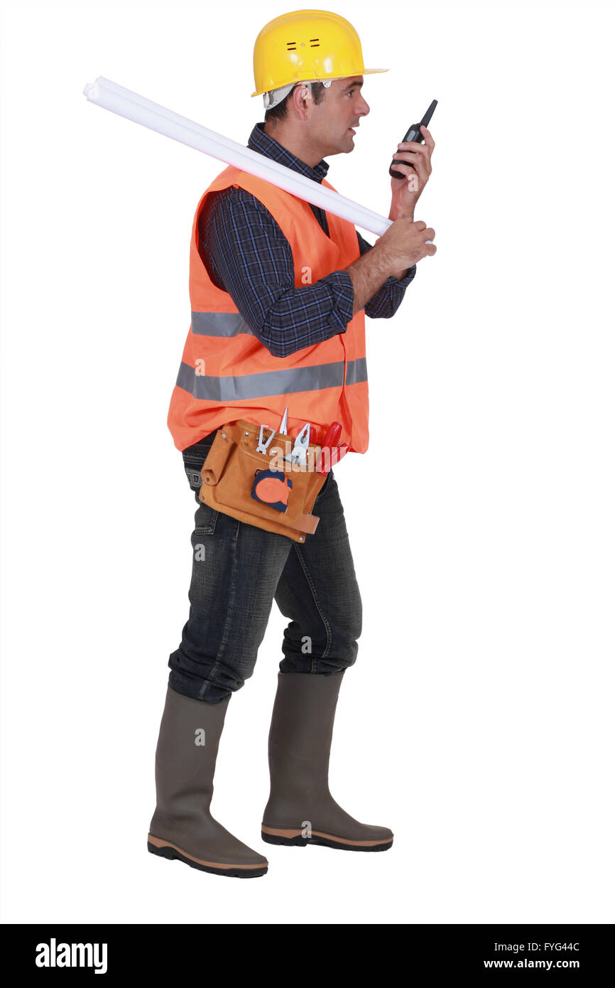 Vorarbeiter mit Blaupausen über seine Schulter und Talkie walkie Stockfoto