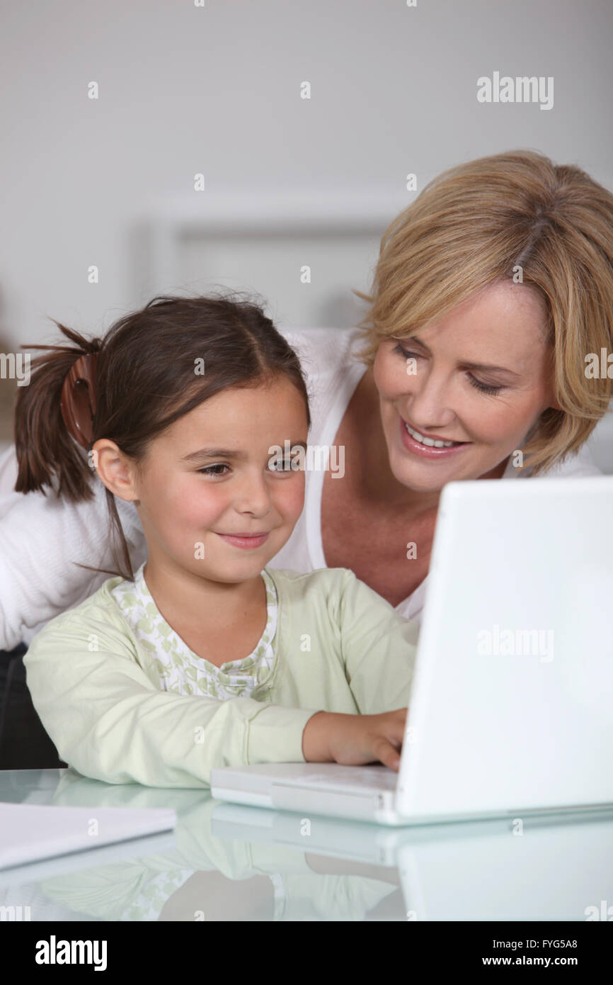 Mutter und Tochter mit einem weißen Laptopcomputer zusammen Stockfoto