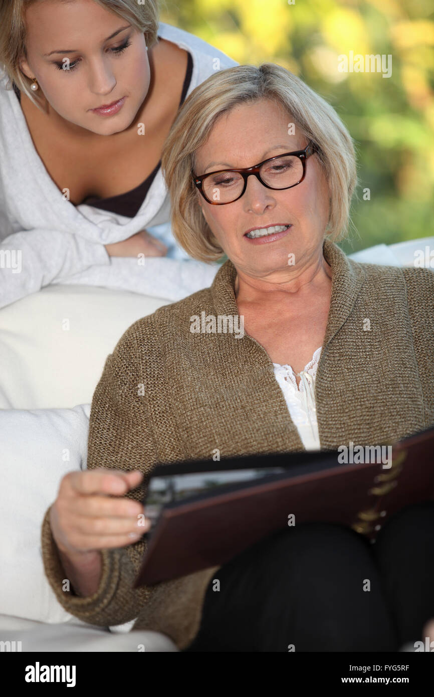 Großmutter und Enkelin blättert in Familienalbum Stockfoto