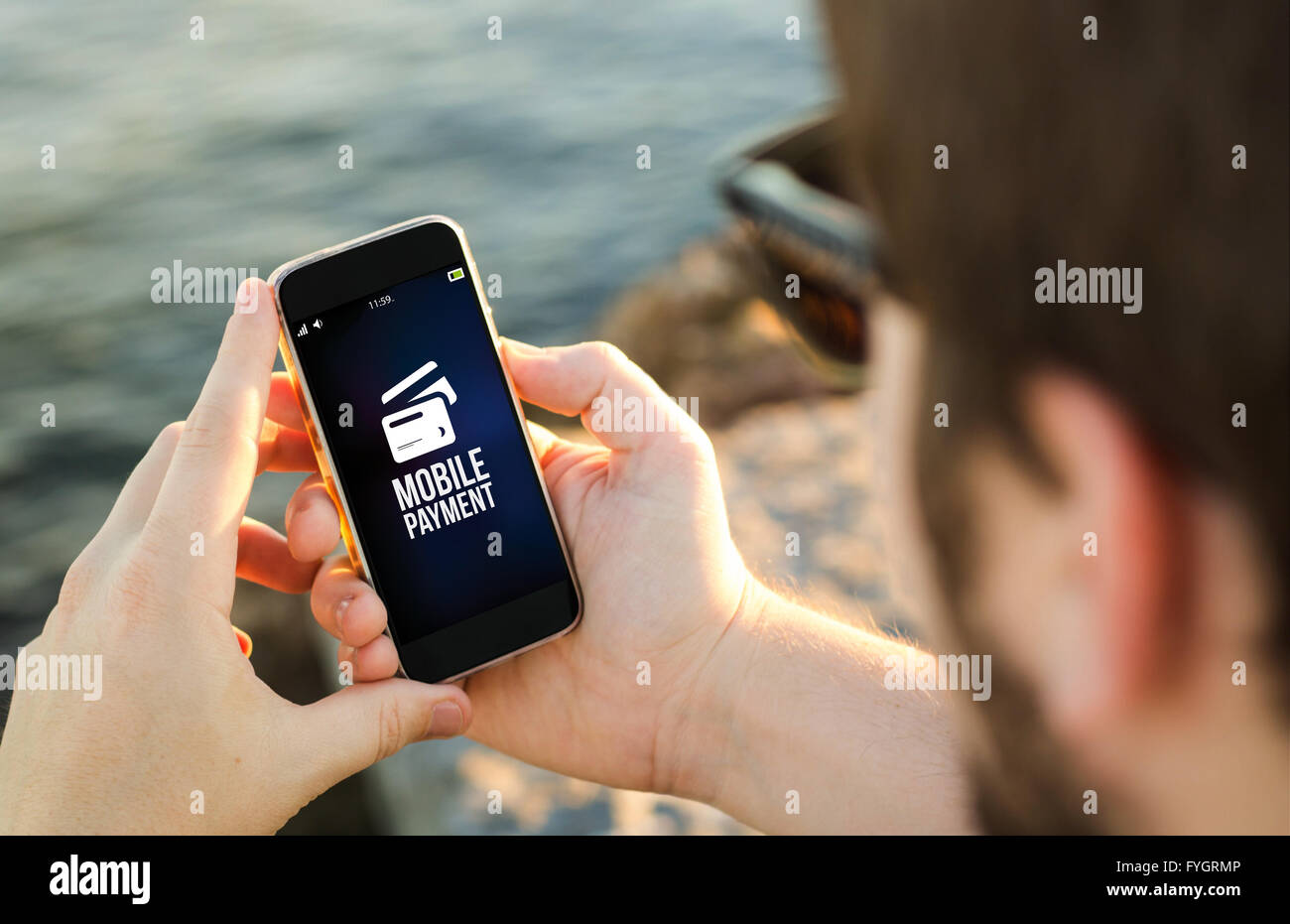 Mann an der Küste mit seinem Smartphone, mobile-Payment. Alle Bildschirm-Grafiken bestehen. Stockfoto