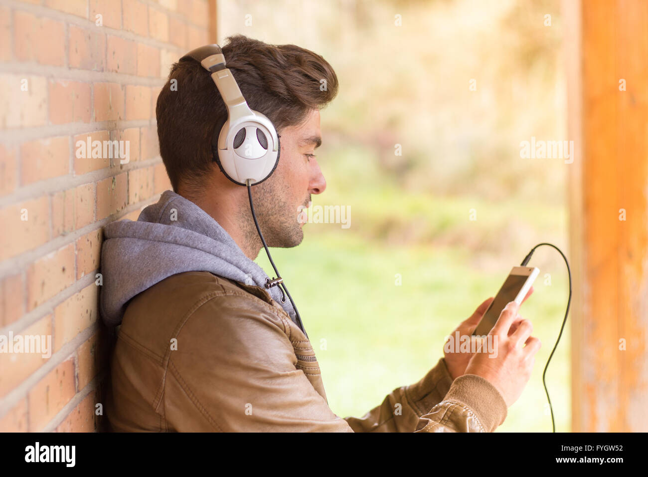 Junger Mann Musik hören mit smartphone Stockfoto