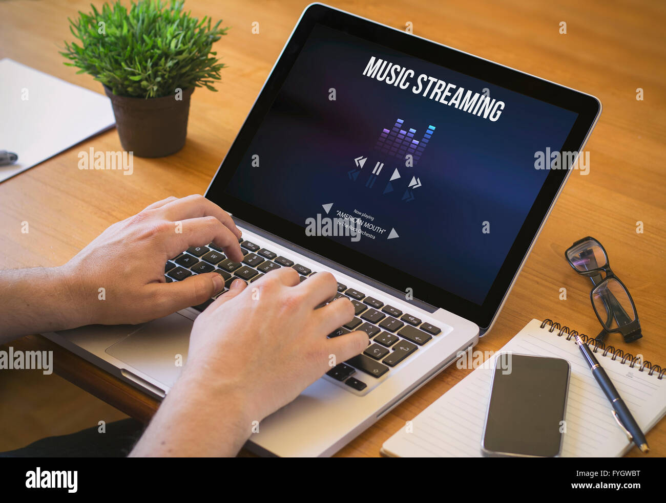 Musik-Streaming-Konzept. Close-up Draufsicht eines Mannes streaming von Musik mit einem Laptop. alle Bildschirm-Grafiken bestehen. Stockfoto