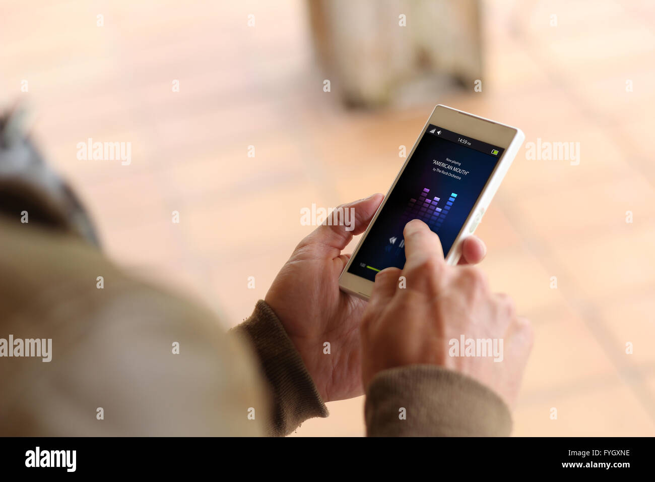 Mann durch Berühren des Bildschirms von seinem Smartphone zeigt Musik-app. Alle Bildschirm-Grafiken bestehen. Stockfoto