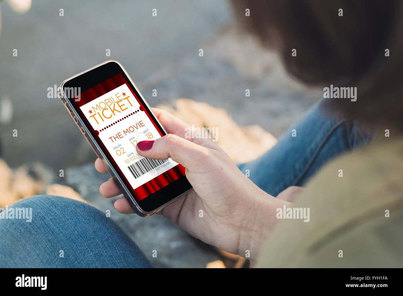 Frau hält eine Smartphone und berühren des Bildschirms mit Kino e-Ticket. Alle Bildschirm-Grafiken bestehen. Stockfoto