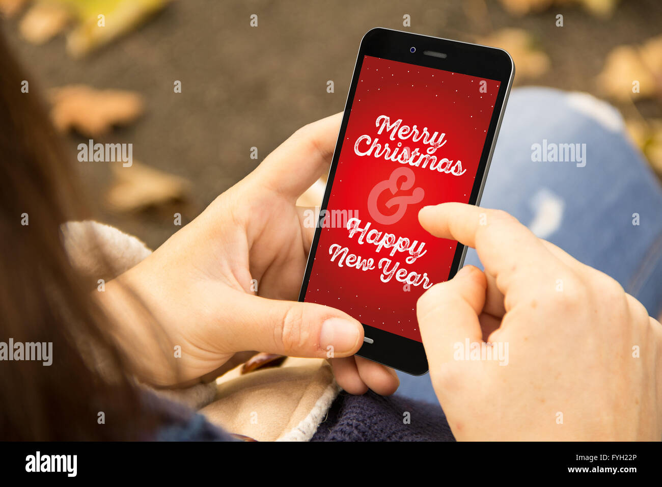 Lifestyle-Konzept: junge Frau mit Weihnachtsgruß auf Handy im Park. Alle Bildschirm-Grafiken bestehen. 3D erzeugt. Stockfoto