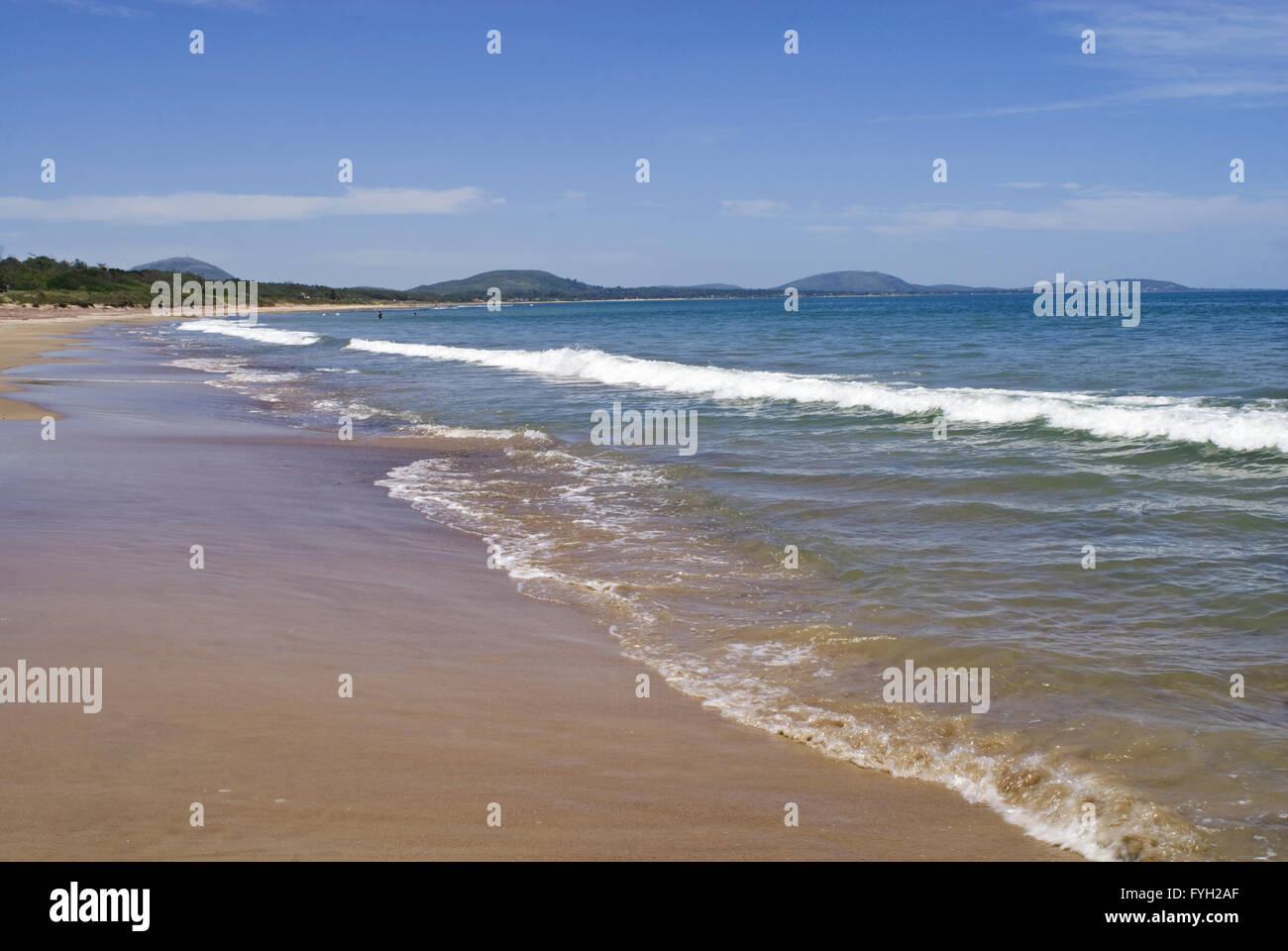 Ruhiger Strandküste mit Meer, Sand und klarem, blauem Wasserwellen. Sommer Urlaub. Stockfoto