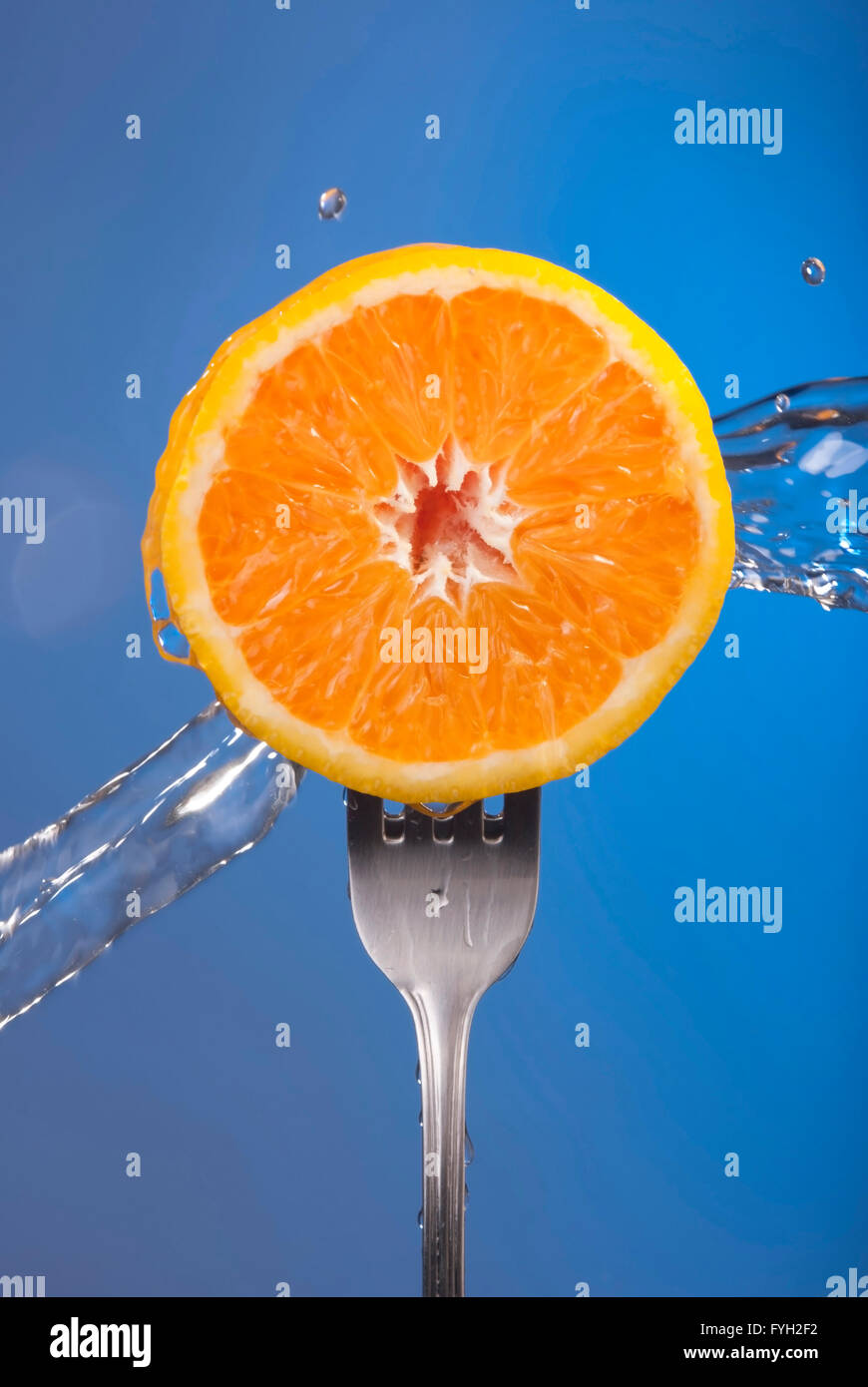 Frische orange Früchte auf Gabel mit lebendigen Farben und kühle Nass Spritzen. Ideal für Bio-Lebensmittel-Kampagne, Gesundheit Poster oder Web. Stockfoto