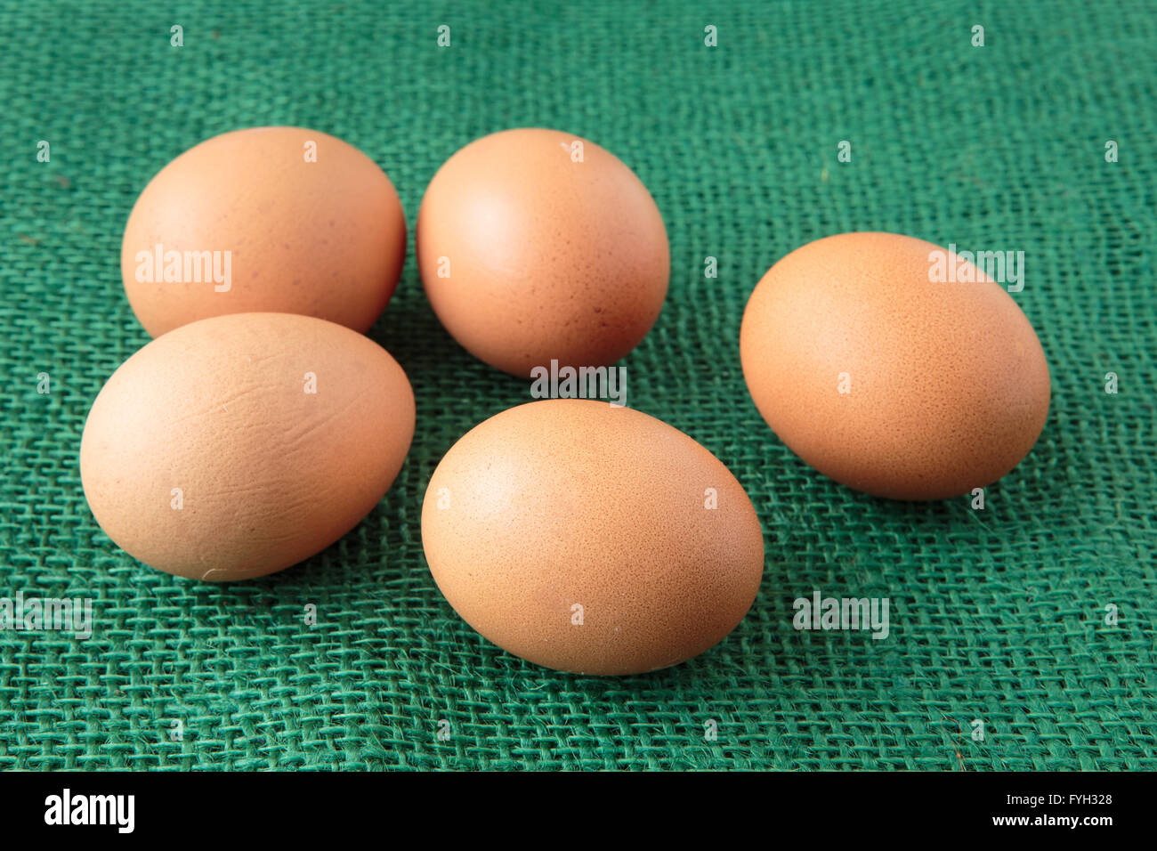 Frische rohe Gruppe von Eiern legen auf grüner sack Stockfoto