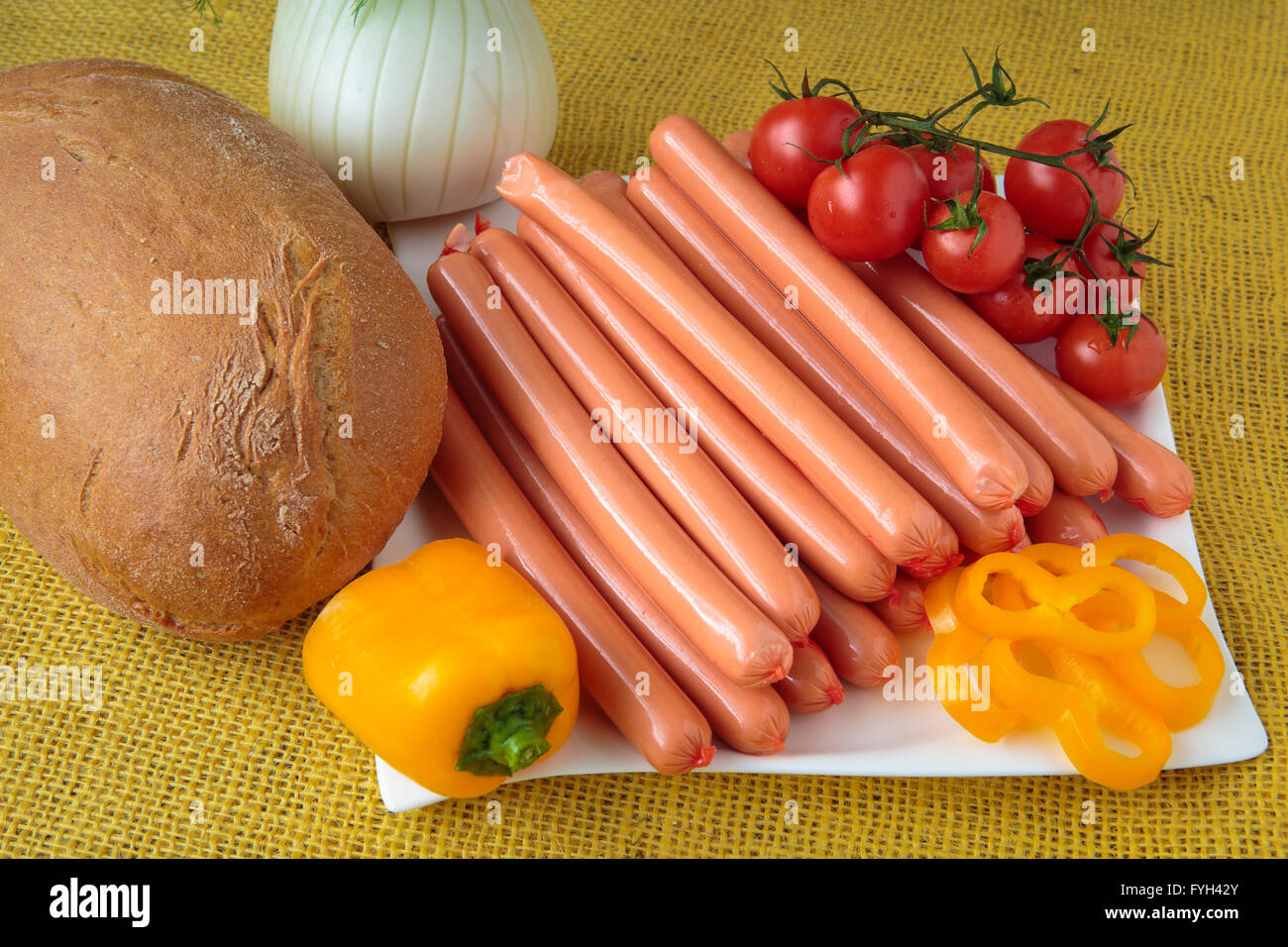 Rohe Frankfurter Würstchen und Brot auf weißen Teller Stockfoto
