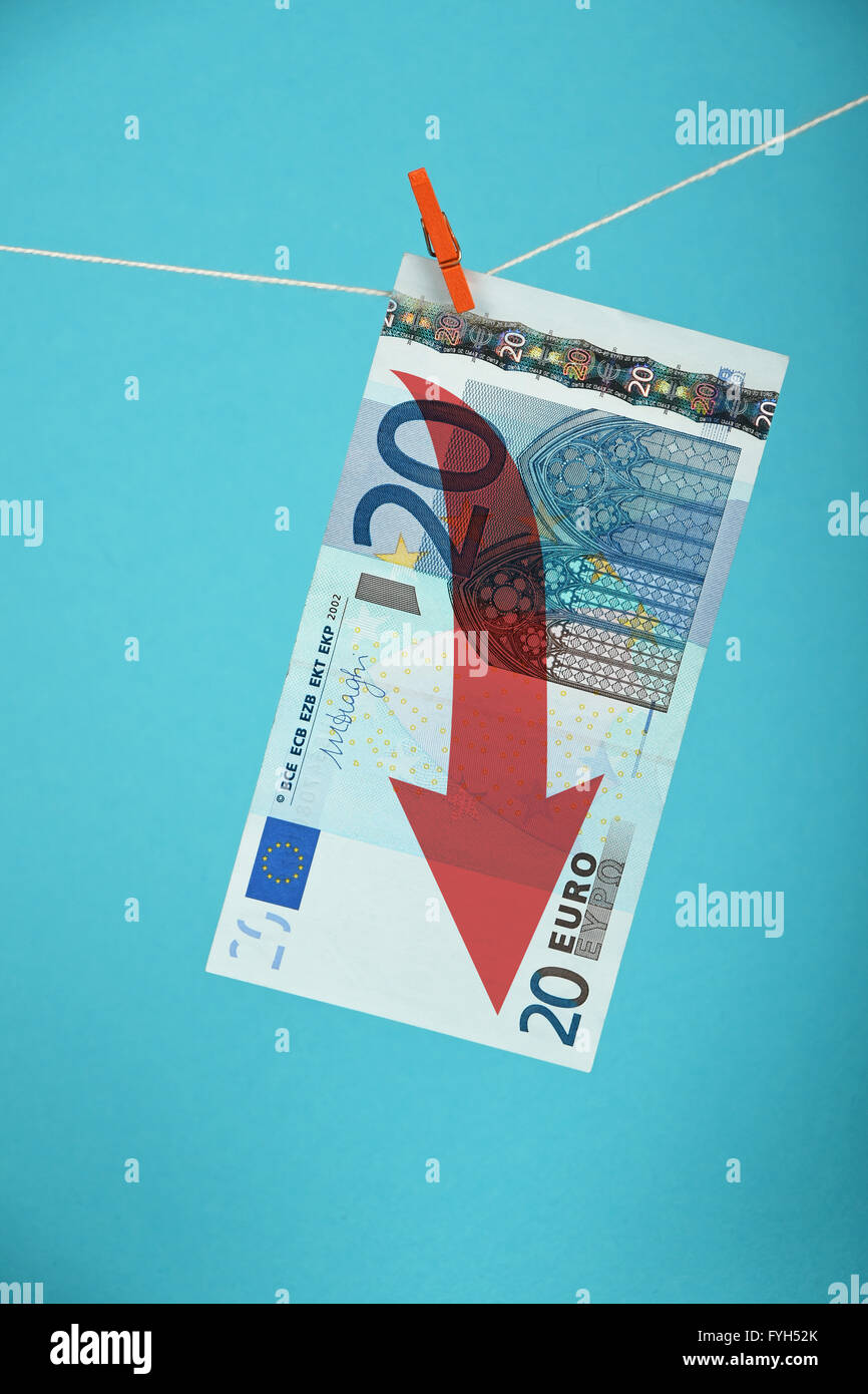 Europäische Wirtschaftskrise, Verfall der Währung Euro, 20 Euro-Banknote mit roten Pfeil nach unten gehängt absteigend mit Pin am Seil o Stockfoto