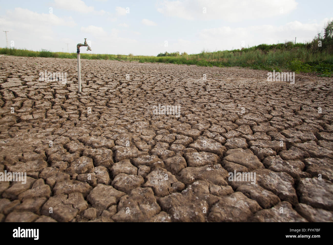 Umweltkonzept, Wasserknappheit und Dürre trockene rissige Schlamm mit einem Wasserhahn Stockfoto