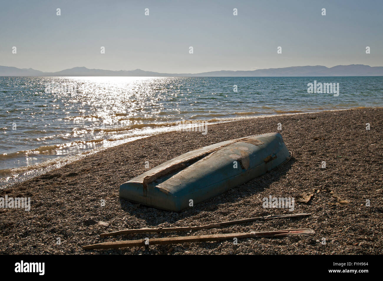 Einen umgedrehten Boot und Rudern auf dem Ufer des Issyk-Kul in Kirgisien. Issyk-Kul ist der 10. größte See der Welt. Stockfoto