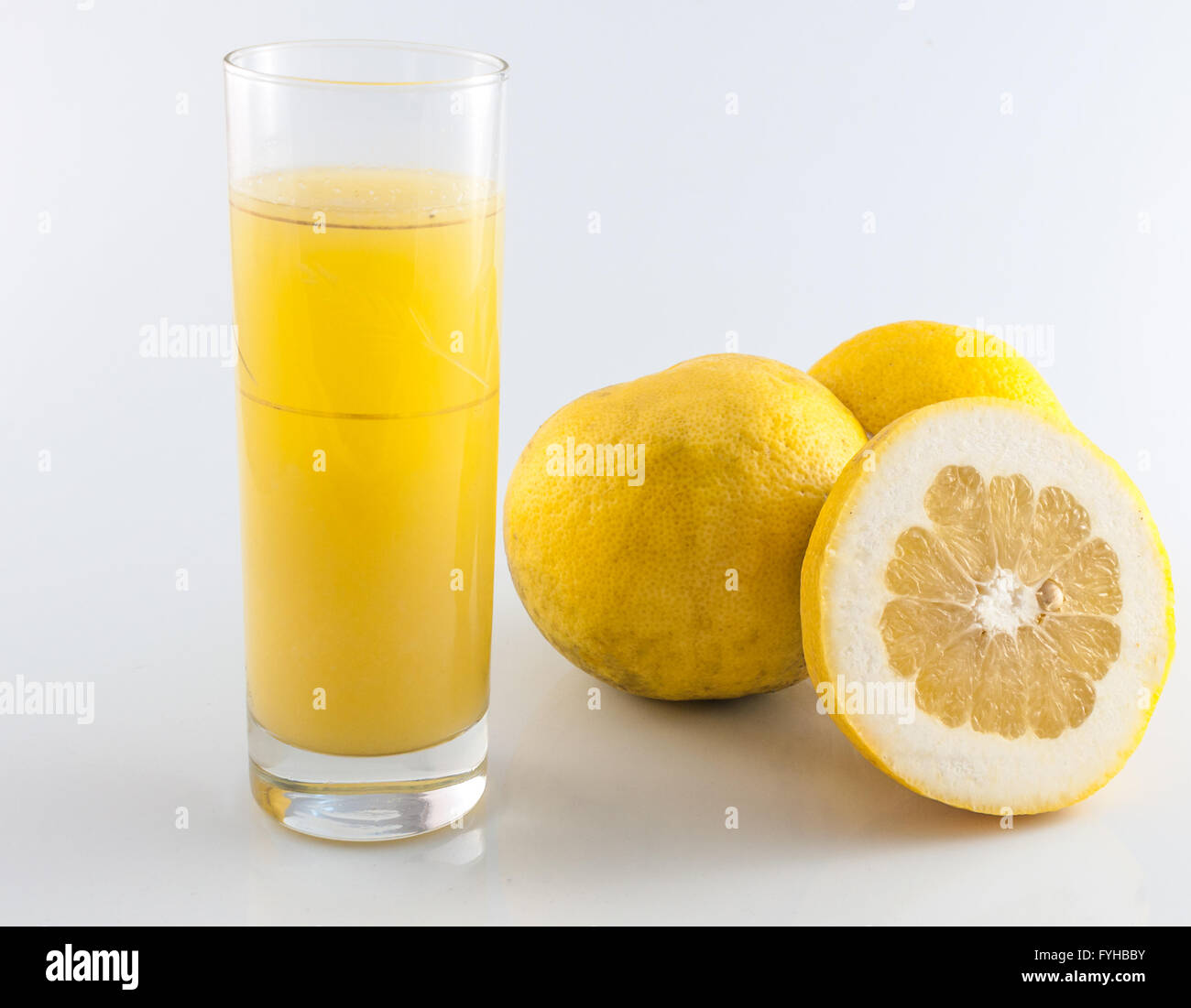 Grapefruit-Saft und Obst auf farbigem Hintergrund Stockfoto