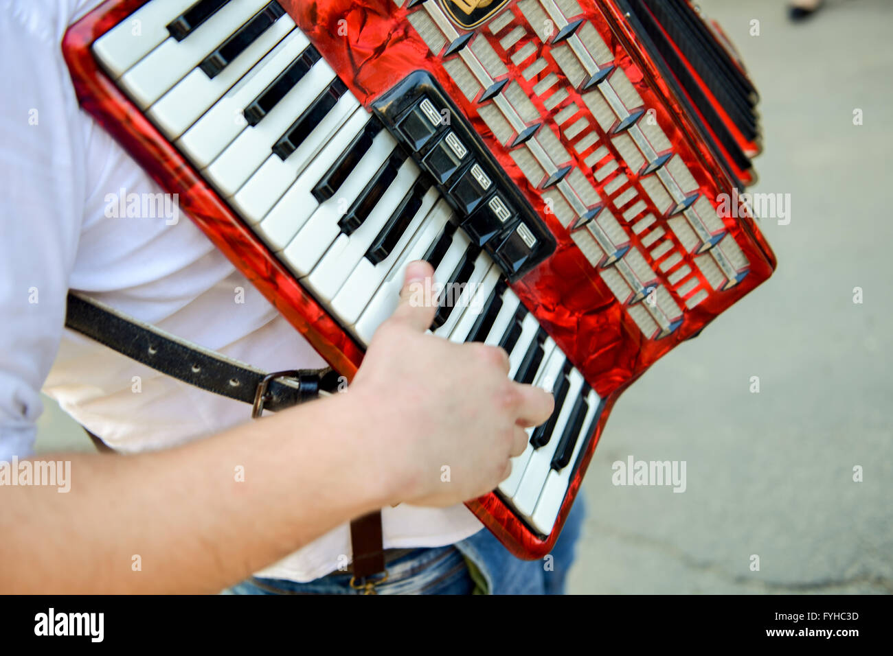 Man spielt auf einem elektronischen Akkordeon bei natürlichem Licht Stockfoto