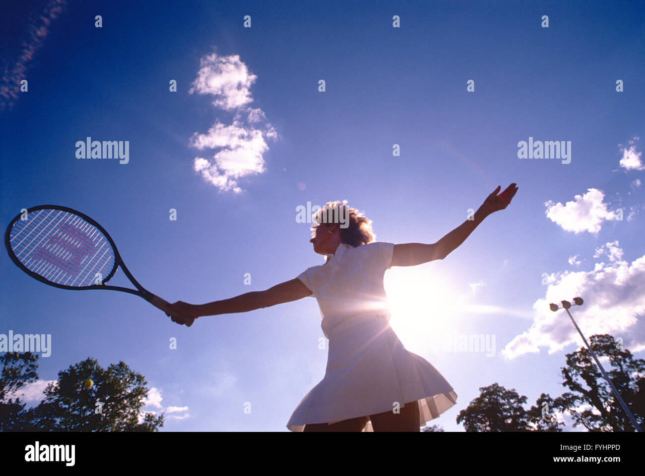 Tennisspielerin, die den Ball mit einem Schläger Stockfoto