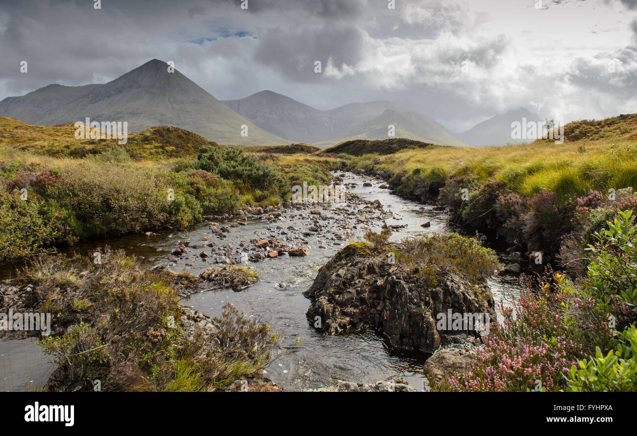 Ein kleiner Fluss auf Moorland auf der Isle Of Skye, erschossen von einem niedrigen Winkel mit den Bergen im Hintergrund. Stockfoto