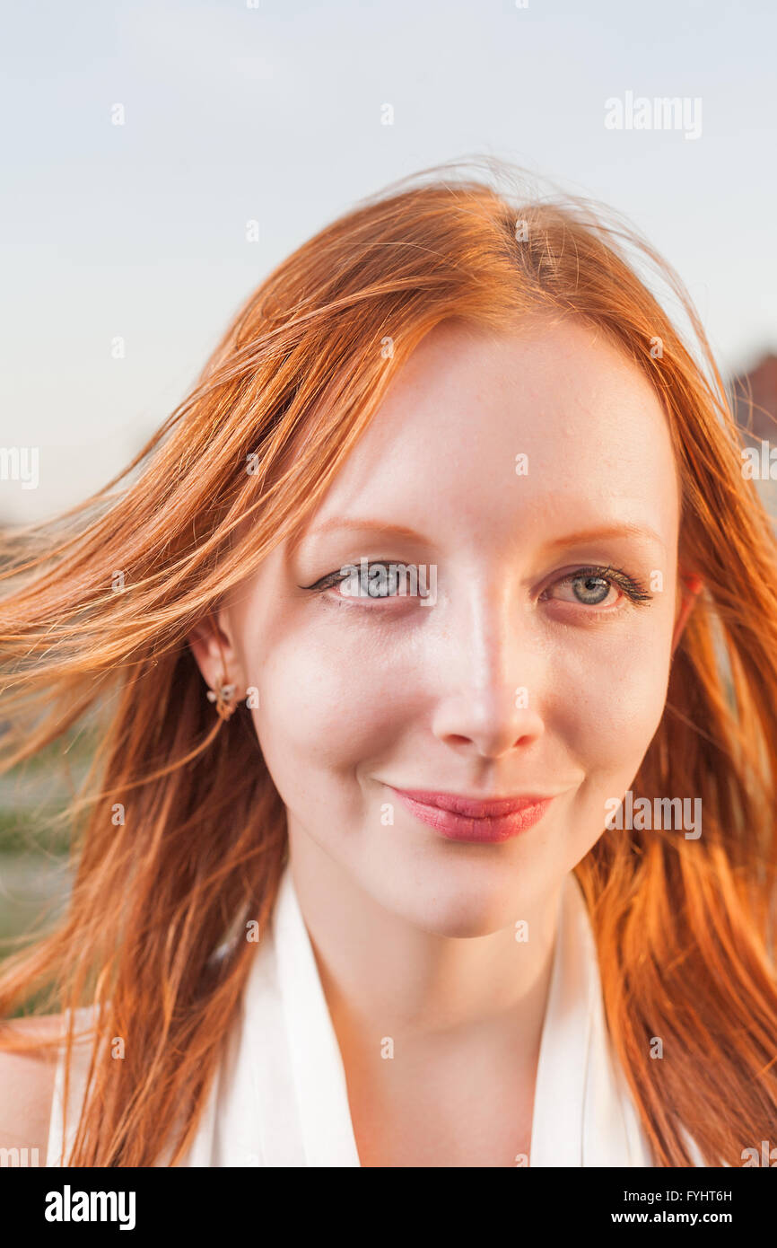 Attraktive Frau mit roten Haaren lächelt glücklich Headshot, Fokus auf Gesicht Stockfoto