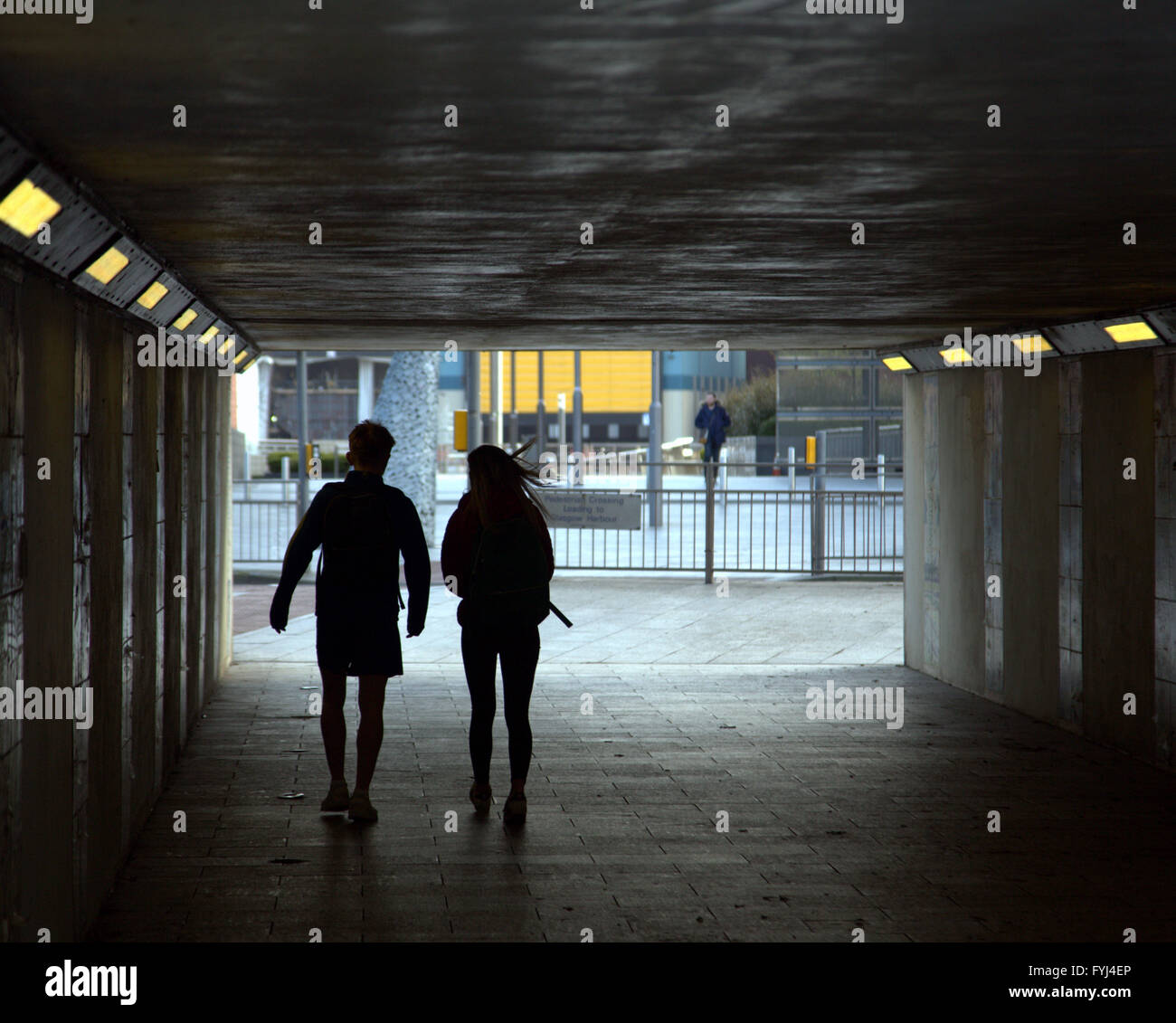 Junges Paar zu Fuß in die Stadt Unterführung silhouette Glasgow, Schottland, Großbritannien Stockfoto