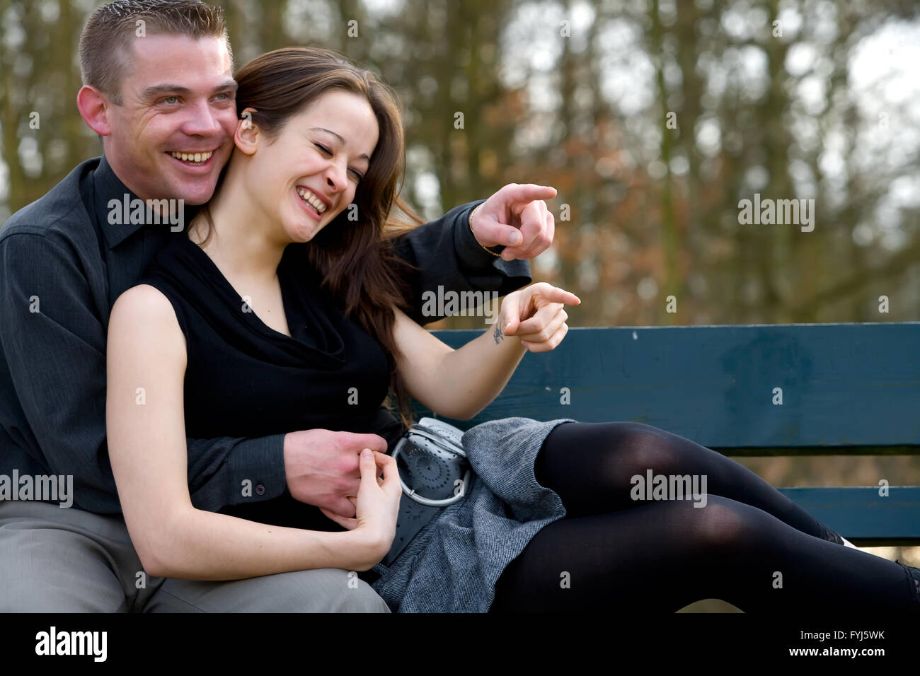 Junges Paar auf einer Bank, die Spaß Stockfoto
