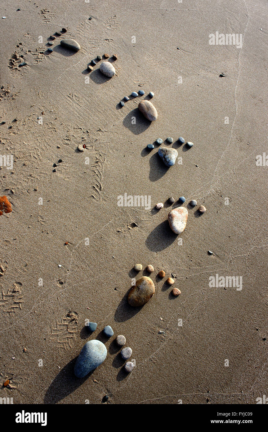 Gruppe des Fußes von Kies auf Sand Hintergrund, erstaunliches Konzept aus Stein mit gelber Farbe am Strand, tolle Kunst-Produkt Stockfoto